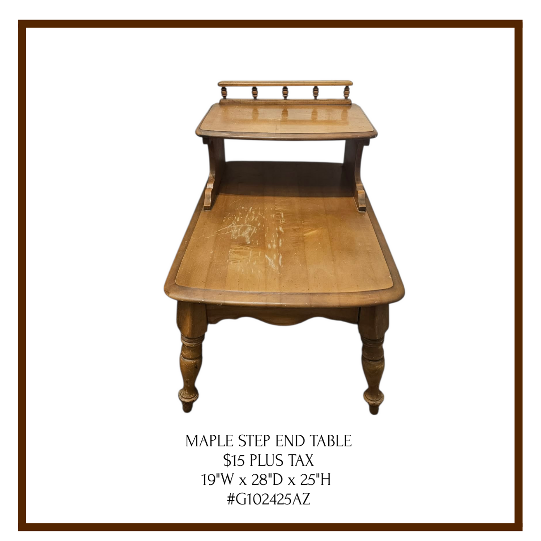 A wooden Maple step end table with a small upper shelf, a larger lower surface, and four turned legs. The surface shows some wear.