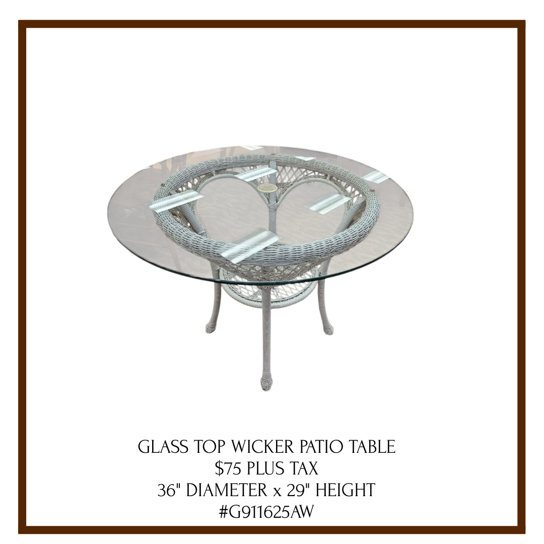 A patio table with a glass top and woven wicker base, priced at $75 plus tax, measuring 36 inches in diameter and 29 inches in height.