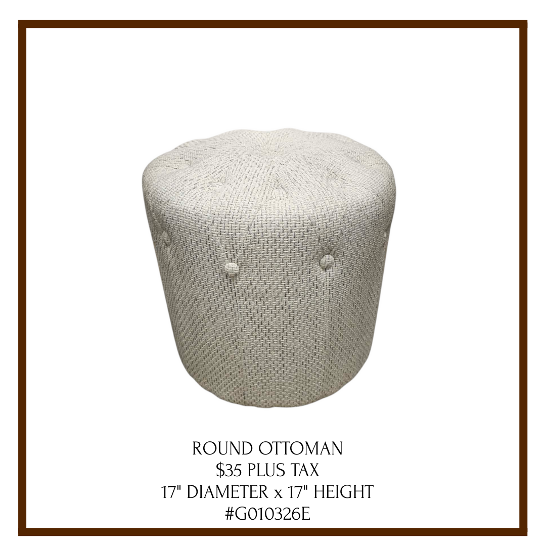 A round, light-colored ottoman with a textured fabric surface and button tufting, displayed on a white background with text below describing its details.