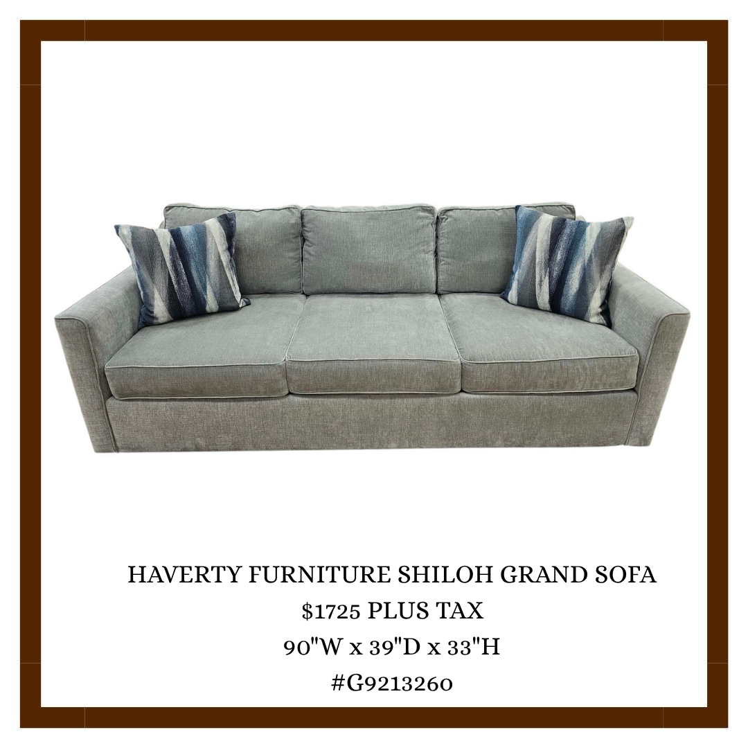 Image of a gray upholstered sofa with three blue and white striped throw pillows.