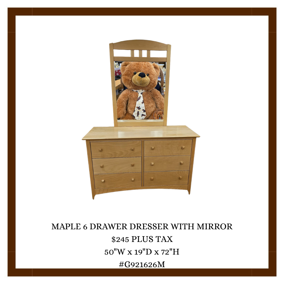 A wooden maple 6 drawer dresser with a mirror, with a large teddy bear in the mirror's reflection.