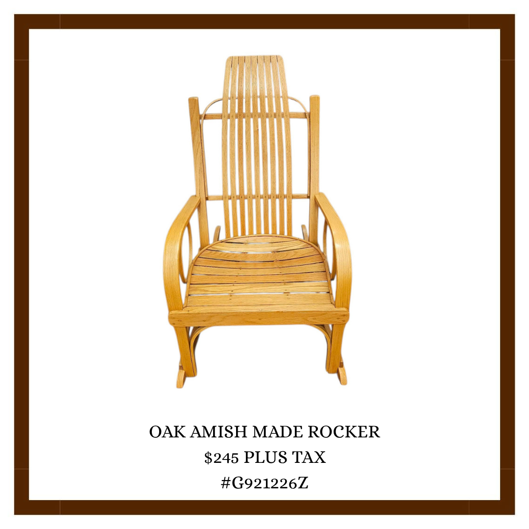 A wooden chair with a high slatted back and curved armrests, labeled as an oak Amish-made rocker.