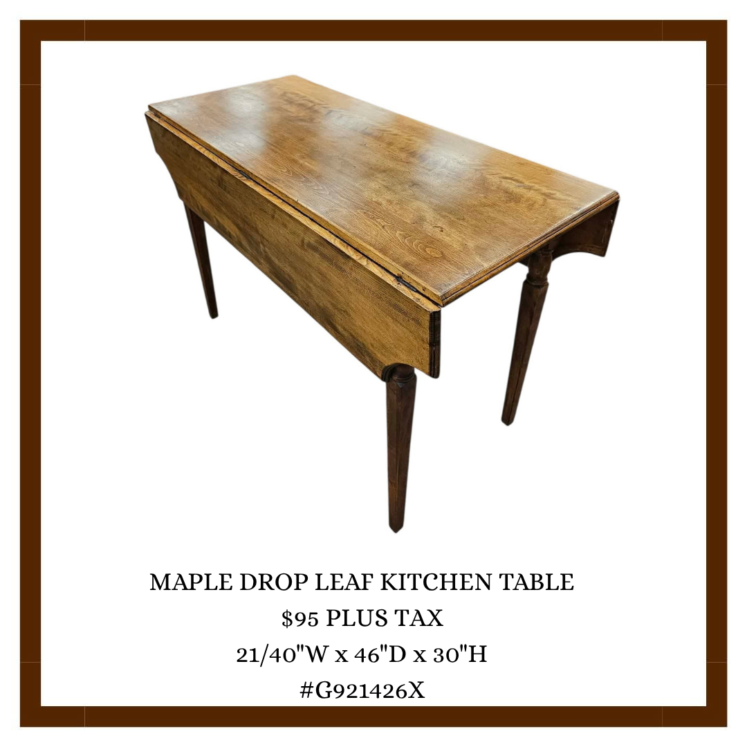A wooden Maple Drop Leaf Kitchen Table with one leaf extended, featuring tapered legs and a natural wood finish.