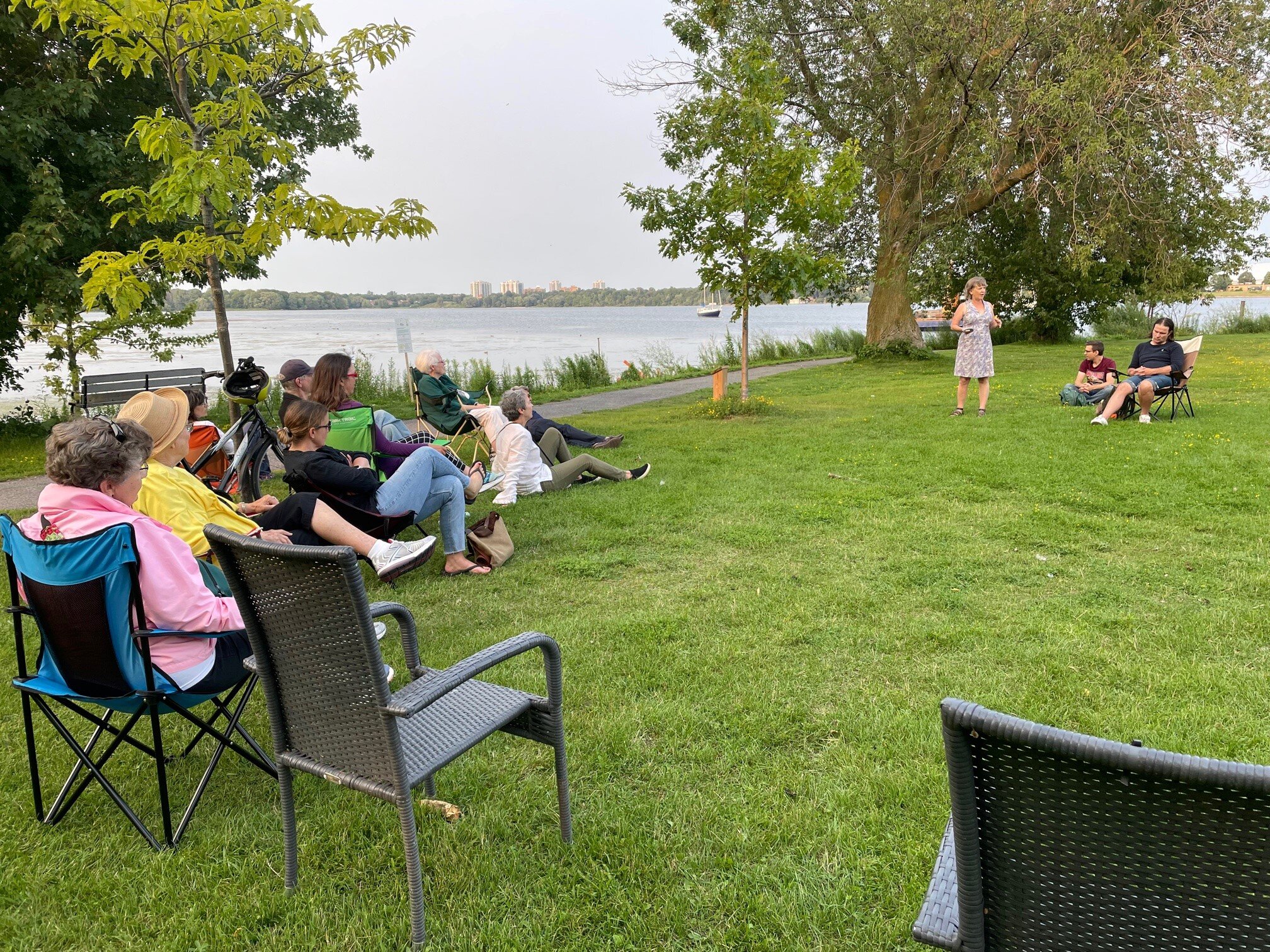 Community members gather in chairs and on the grass for an informal chat about the future of the Cataraqui River.