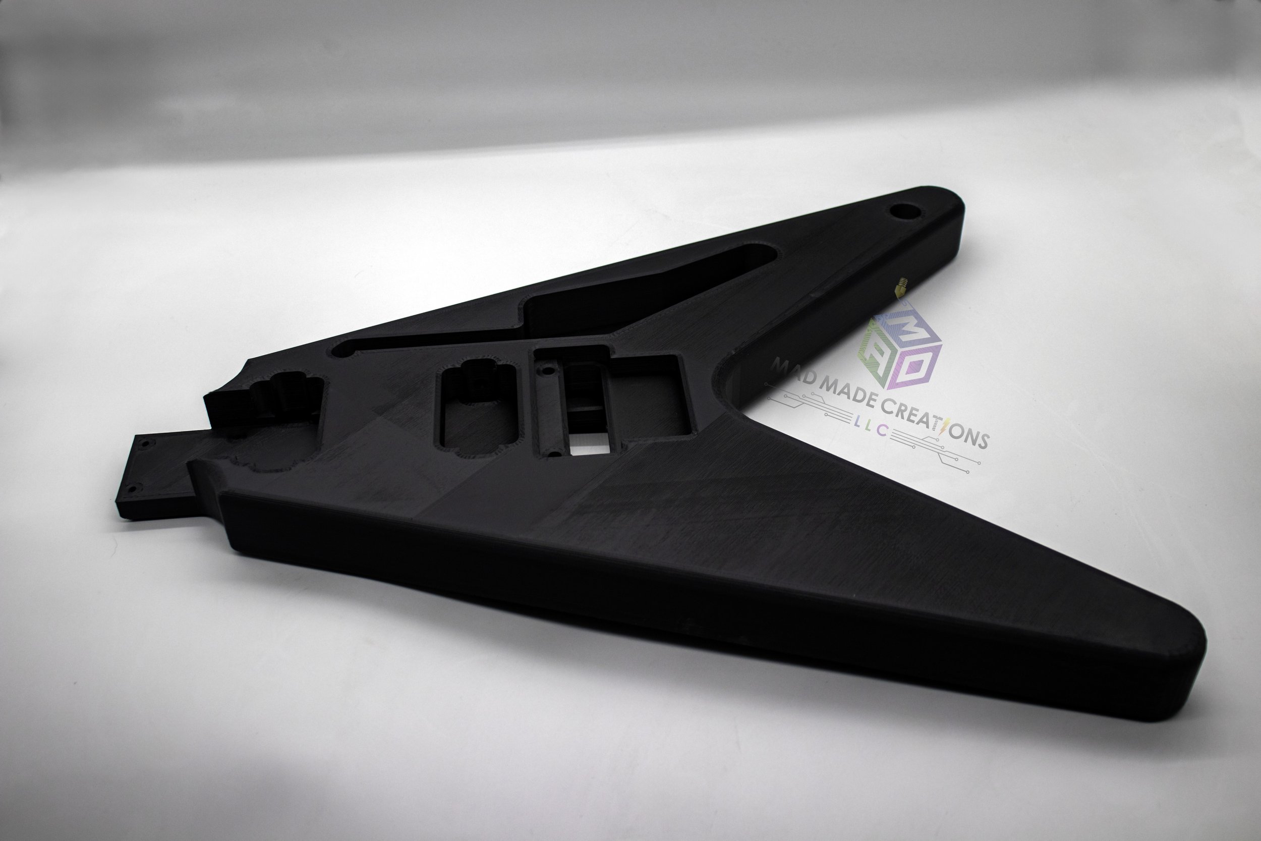 Top angled view of unpainted black 3D printed 1983 Flying V style guitar body featuring HH pickup routing and Floyd Rose tremolo compatibility, made by MAD Made Creations LLC