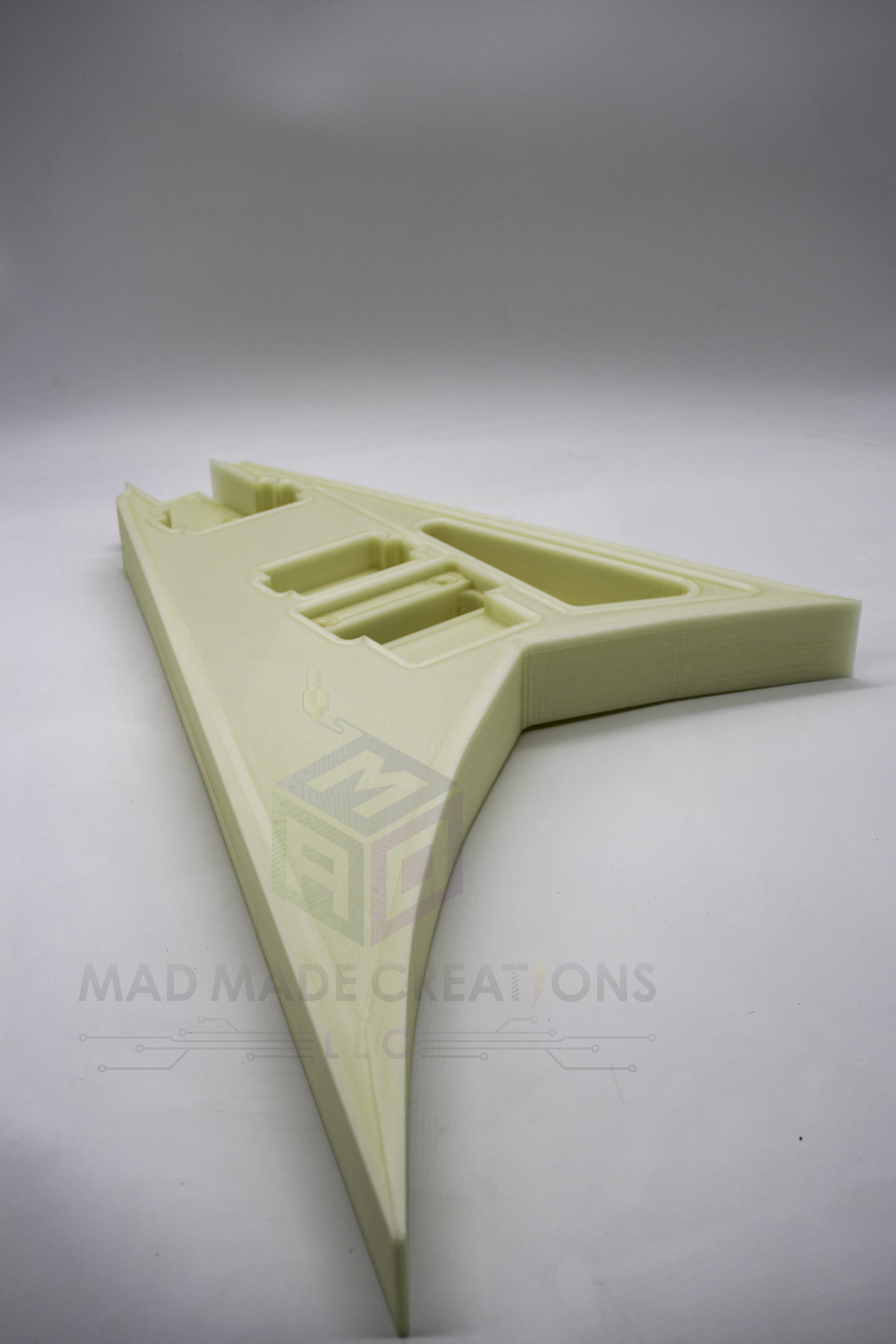 Front view of a one-piece glow-in-the-dark 3D-printed RR3 Randy Rhoads V-style guitar body shown in daylight, routed for HH pickups and Floyd Rose tremolo
