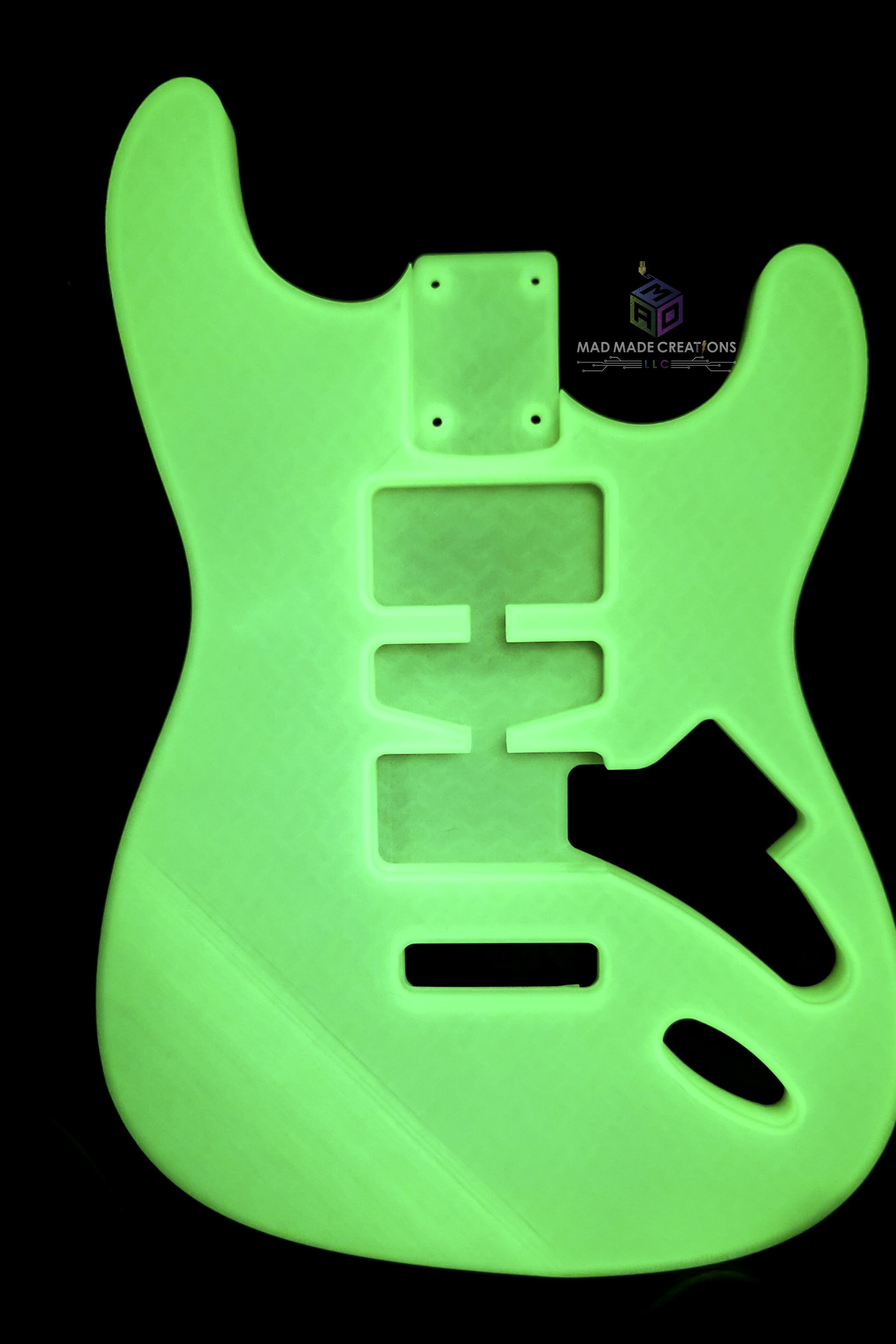 Strat HSH style guitar body glowing in the dark – custom one-piece 3D printed guitar body featuring Floyd Rose routing by MAD Made Creations