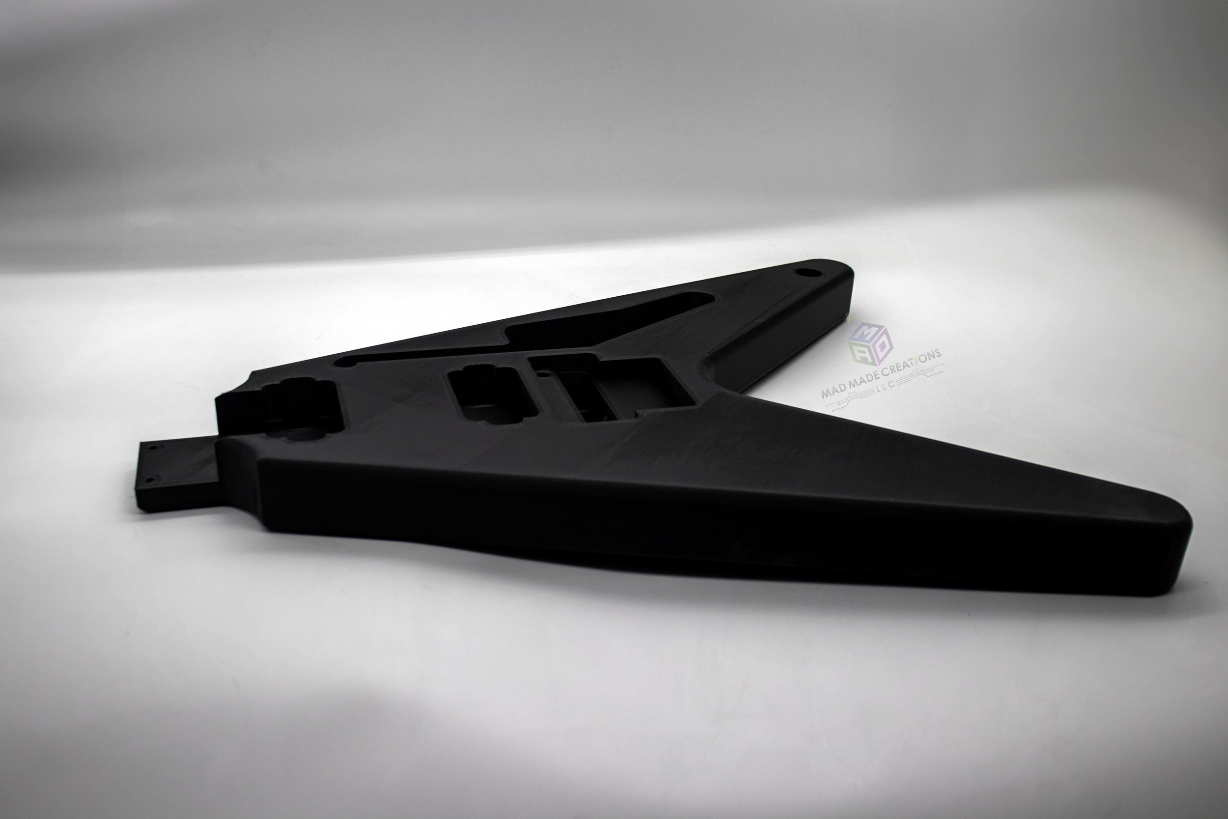 Close-up angled side view of a custom 3D printed 1983 Flying V style guitar body in matte black PLA, featuring Floyd Rose tremolo compatibility and HH pickup routing by MAD Made Creations LLC