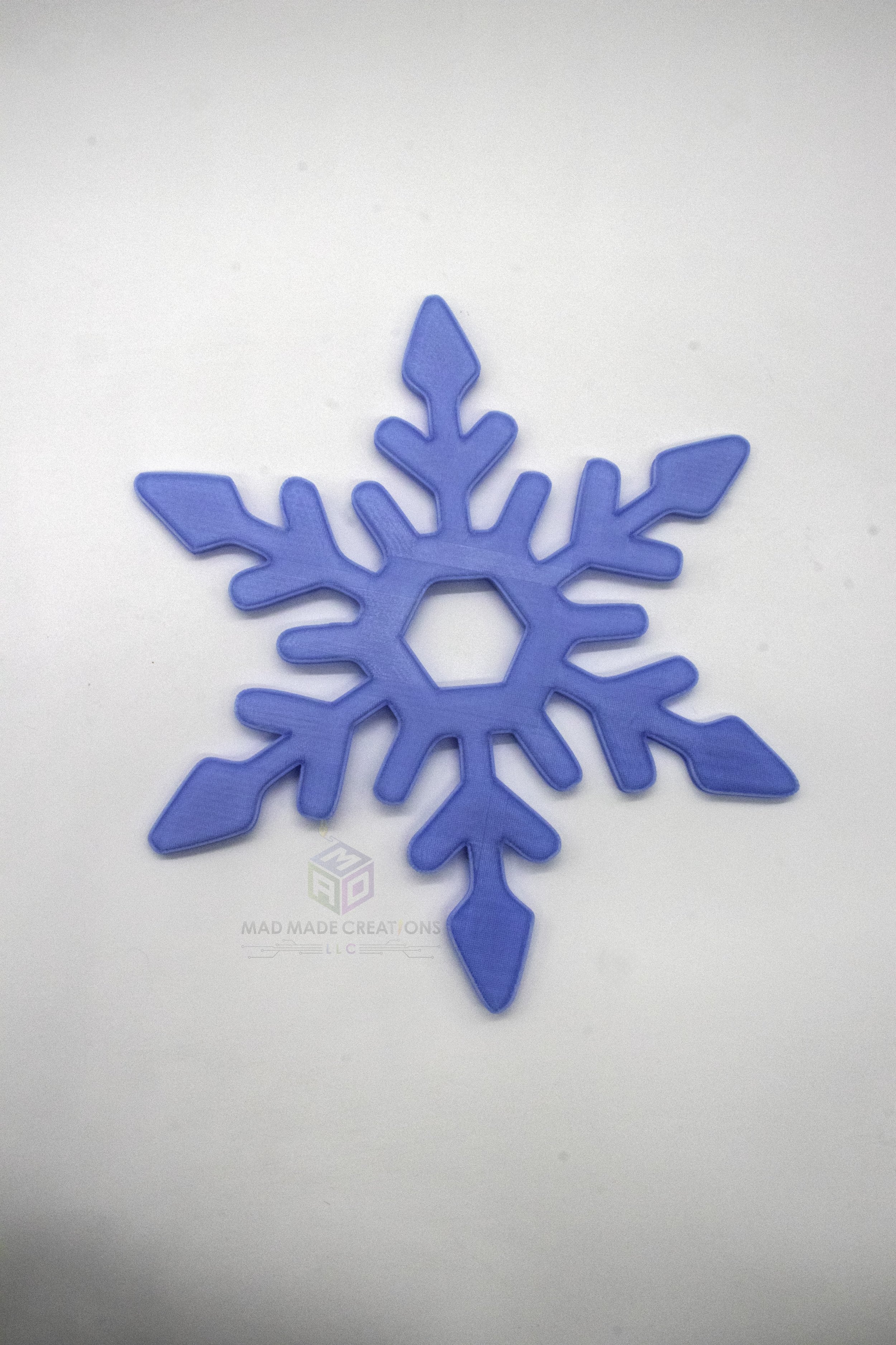Single 12-inch 3D printed blue glow-in-the-dark snowflake ornament with geometric design, part of 4-pack by MAD Made Creations