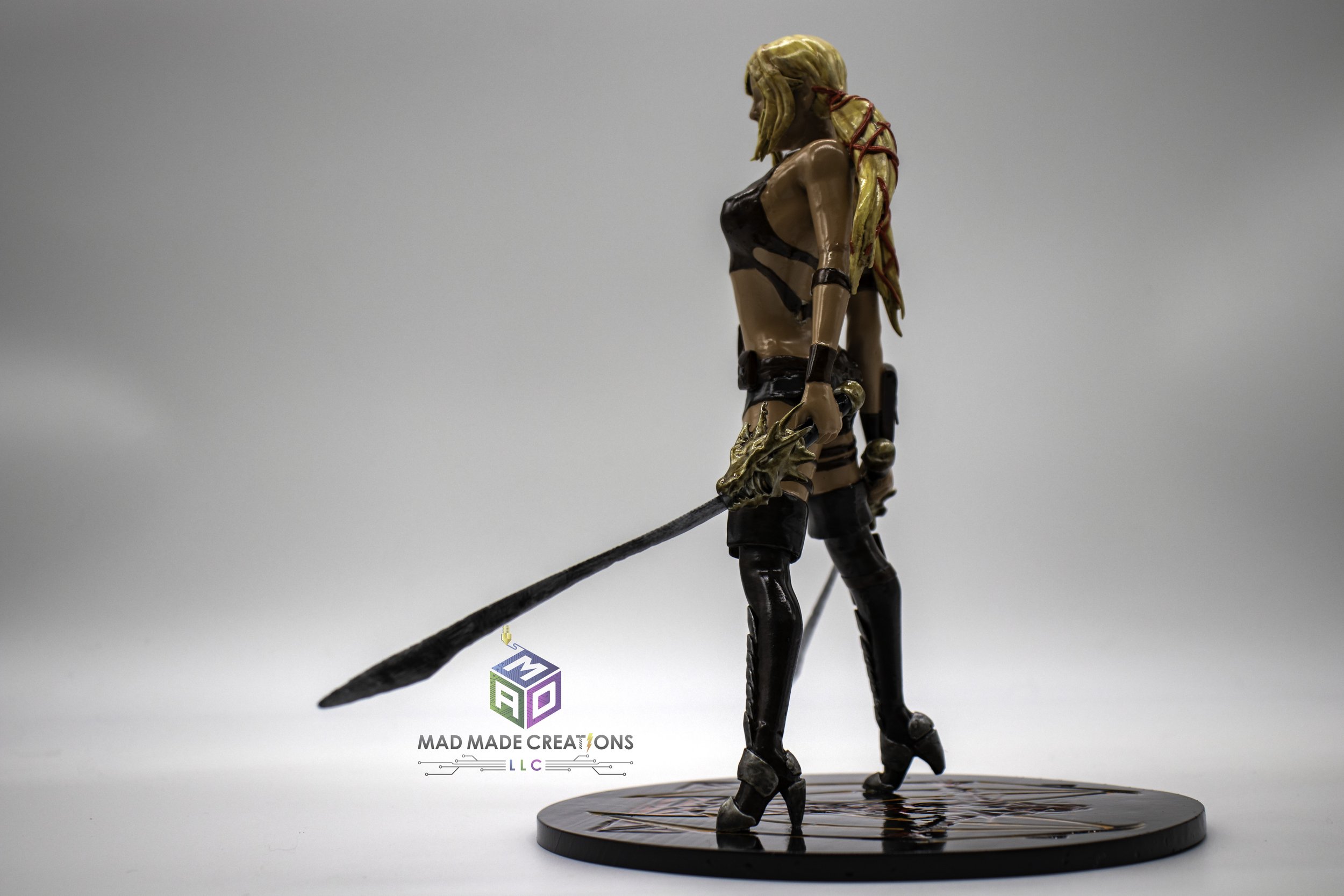 ide view of custom 3D printed and hand-painted female treasure hunter fan art statue holding dual dragon-hilt swords, created by MAD Made Creations using SLA resin printing technology