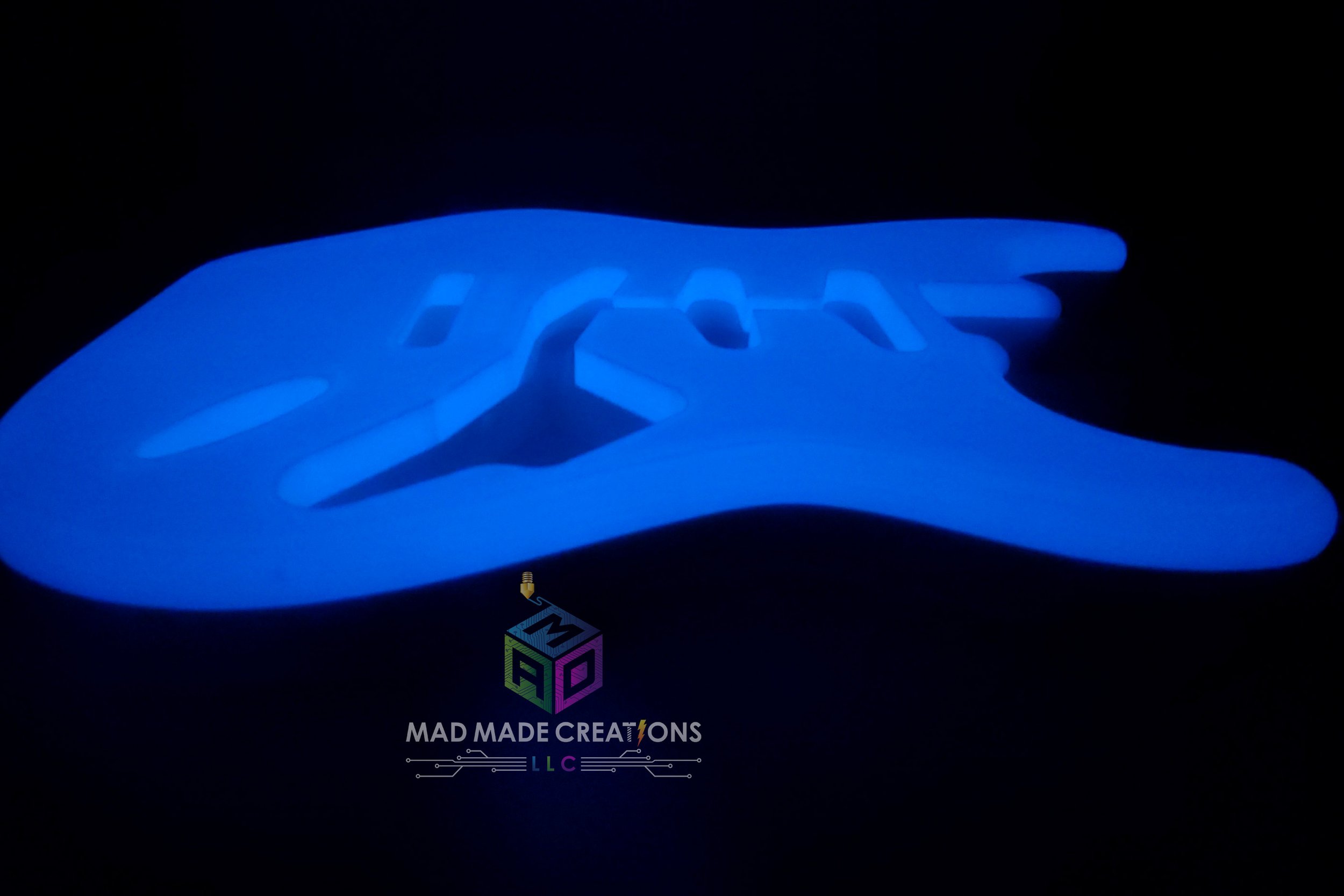 Blue glowing Strat SSS style guitar body in side view – custom one-piece 3D printed glow-in-the-dark guitar by MAD Made Creations