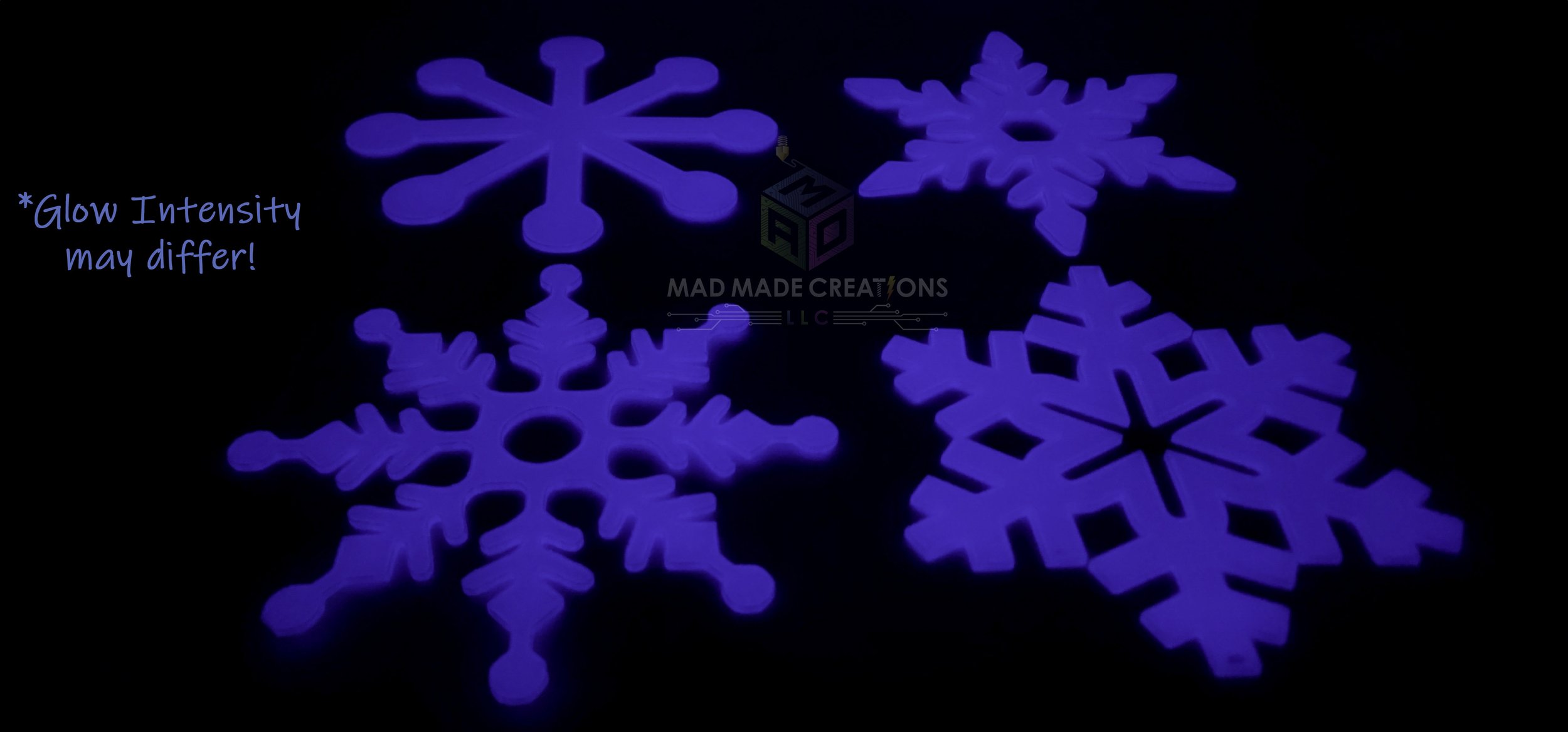 Set of four 12-inch 3D printed blue snowflake decorations by MAD Made Creations glowing in the dark with note about varying glow intensity; part of hangable glow-in-the-dark snowflake 4-pack