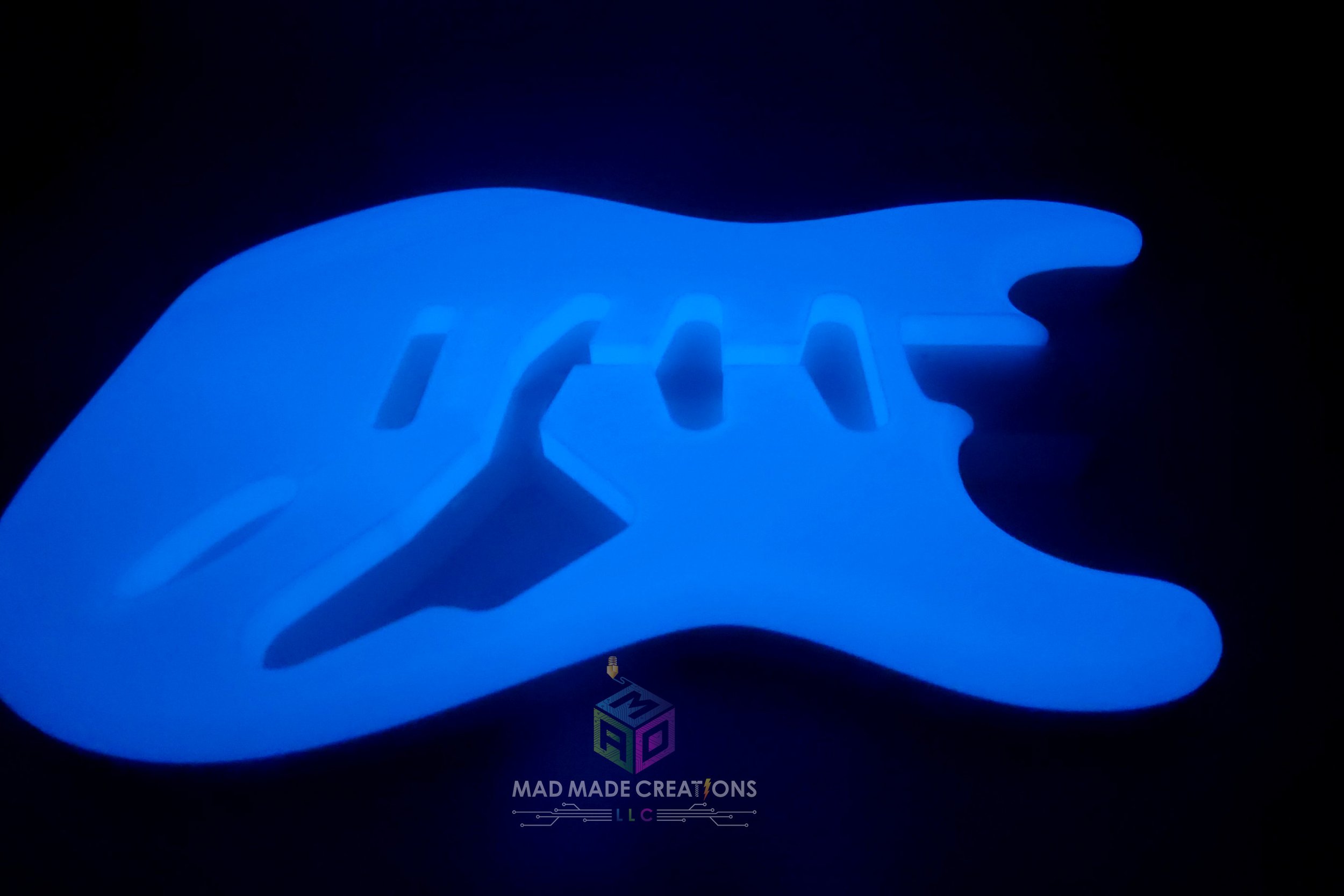 Side view of glowing blue Strat SSS style guitar body – custom one-piece 3D printed glow-in-the-dark guitar by MAD Made Creations