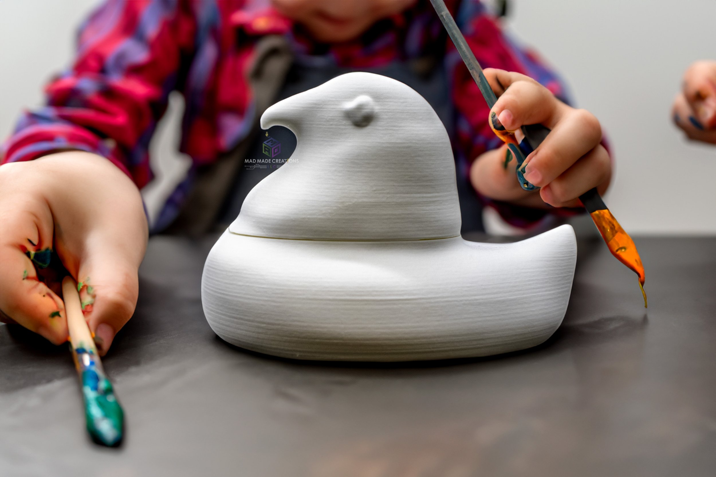 Child painting a white 3D printed Easter chick candy dish as a DIY craft project, hands holding colorful brushes, by MAD Made Creations