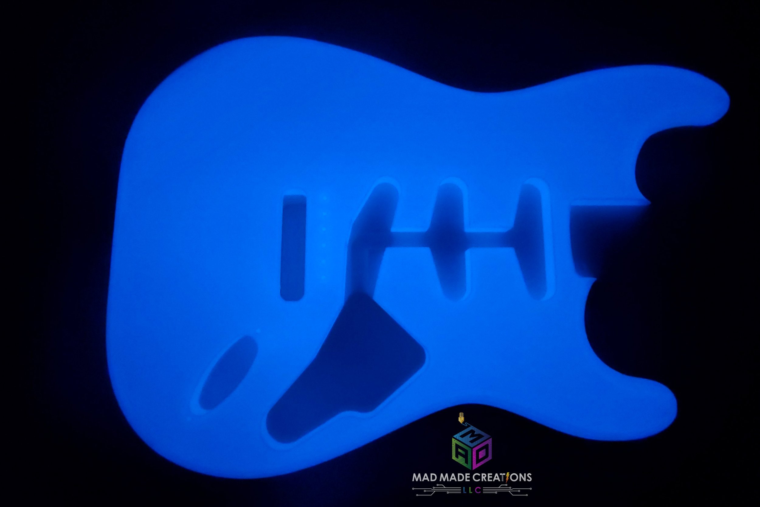 Top view of glowing blue Strat SSS style guitar body – custom one-piece 3D printed glow-in-the-dark guitar by MAD Made Creations
