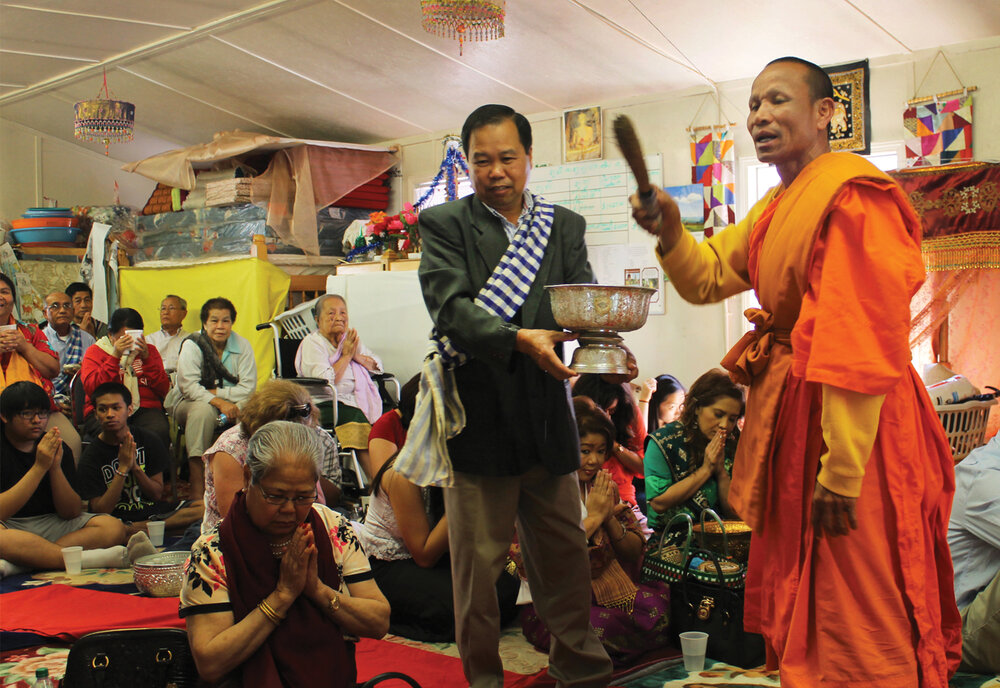 Morganton’s resident monk, Somchit Sengdavone, blesses worshipers by sprinkling water during the Pi Mai ceremony.