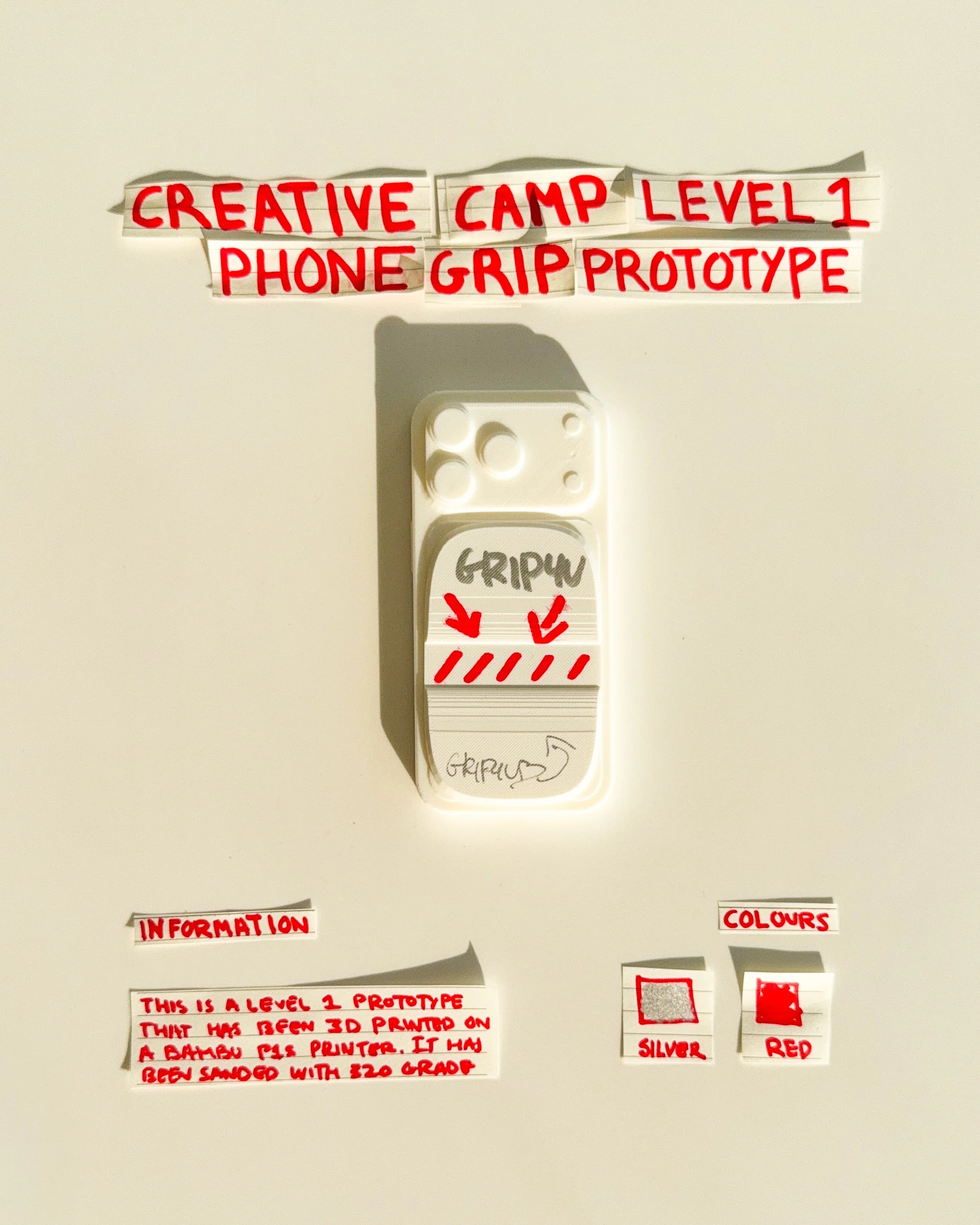 day 23 prototype 21: develop a white rectangular phone grip featuring two circular graphics and a horizontal finger opening. the design explores the relationship between repeated shapes, finger placement and red detailing.