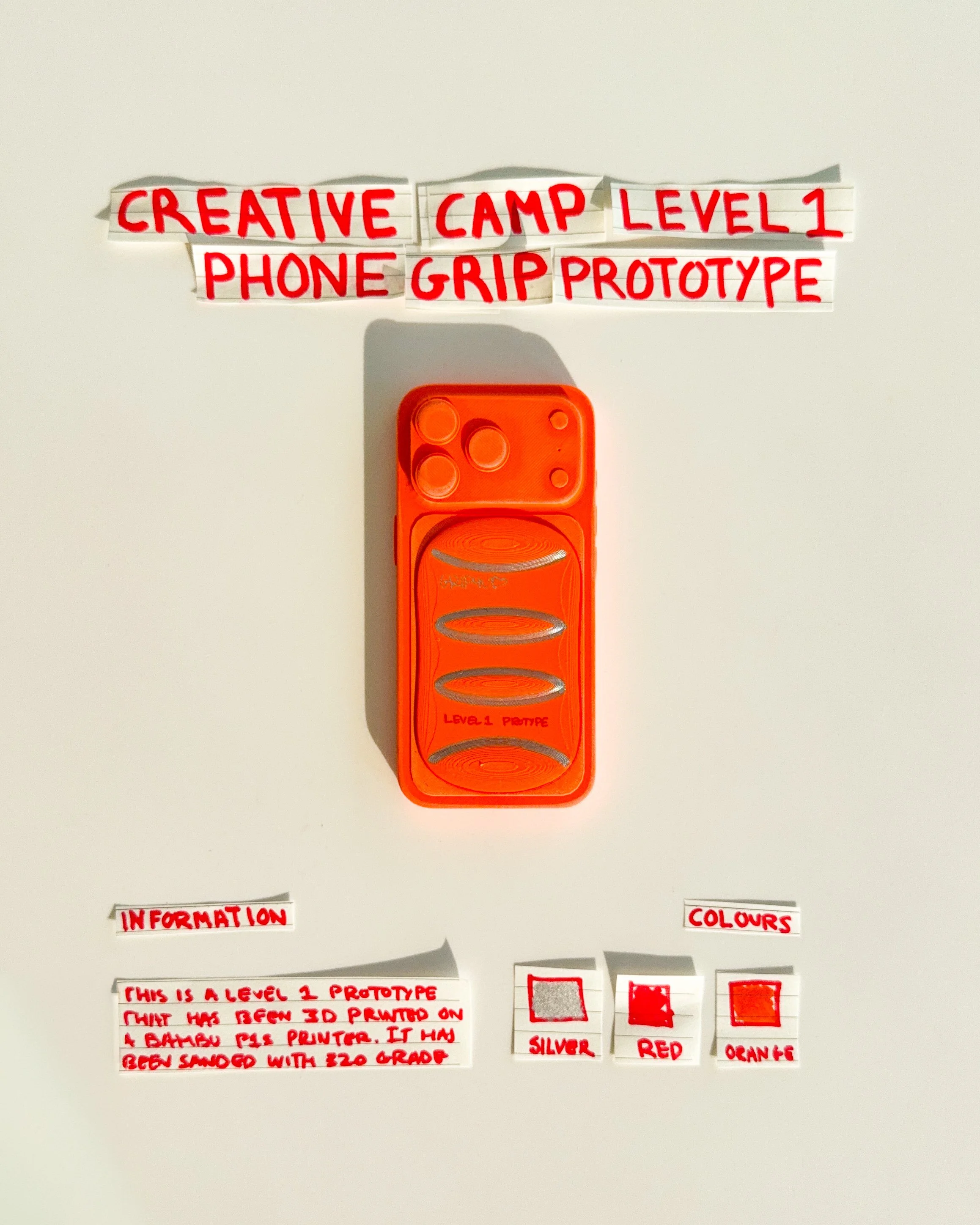 day 27 prototype 25: explore an orange rectangular phone grip featuring three horizontal oval openings and silver detailing. the design focuses on repeated geometry, finger placement and creating a more functional visual identity.