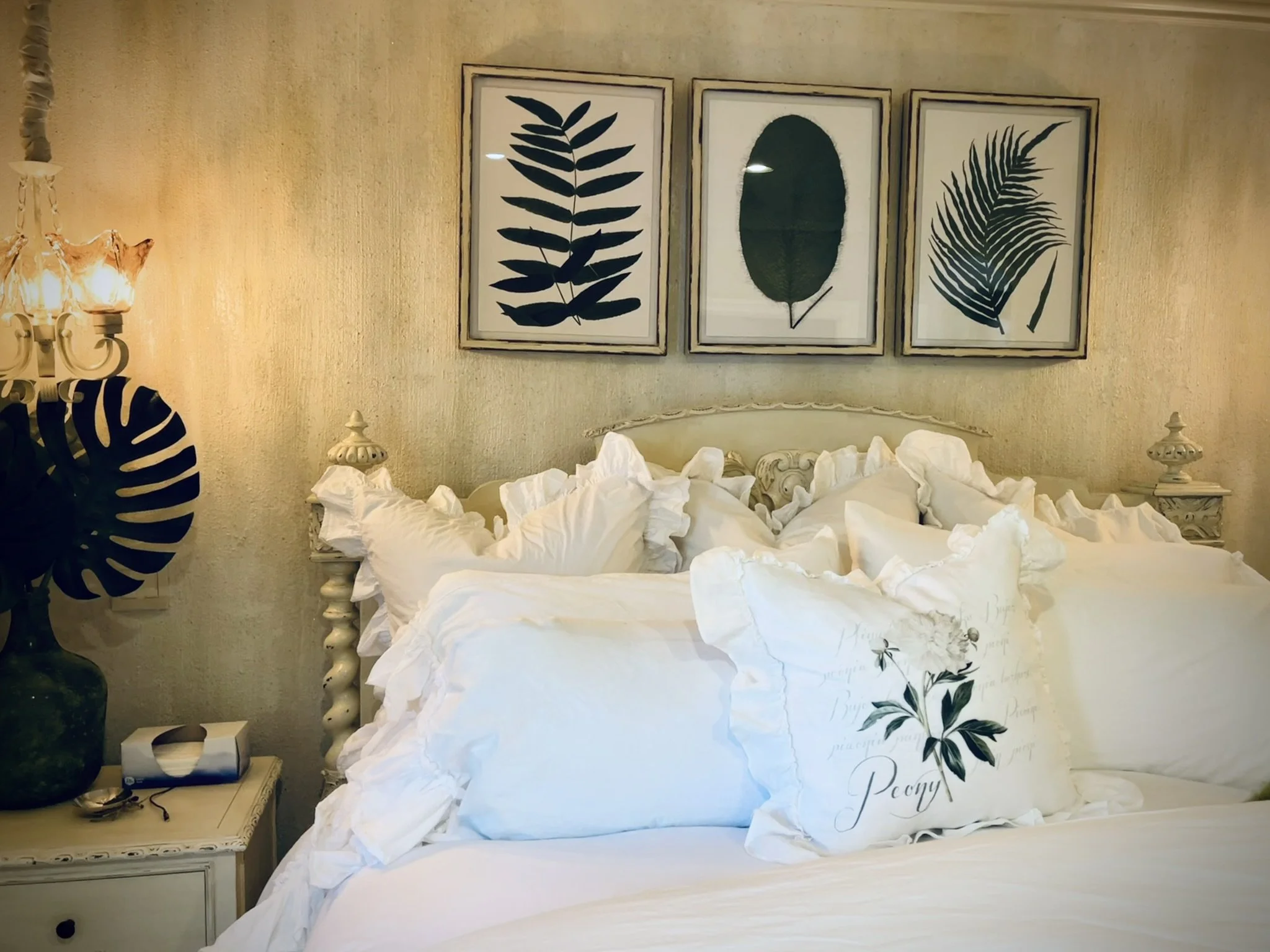 This guest room features a finish of glass beads and glitter on the walls, paired with furniture that has been painted and distressed to give a comfortable, cozy feel.