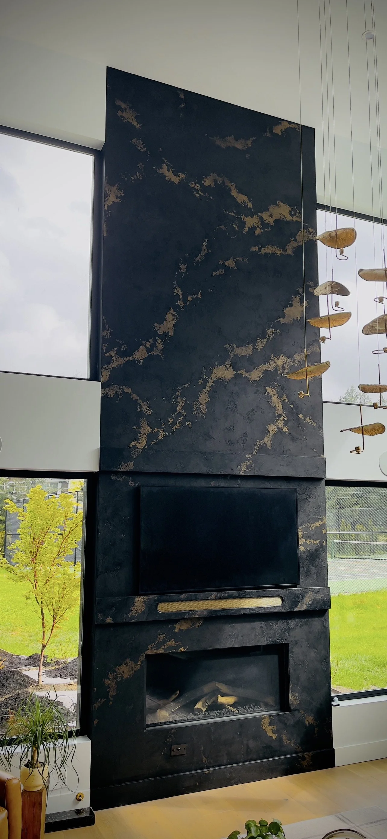 Black Italian Lime Plaster fireplace with brass colored veining.
