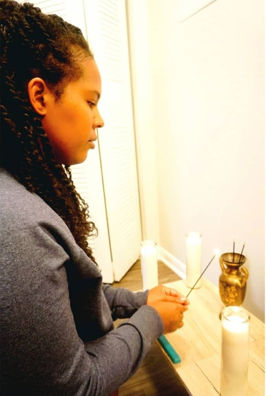 Black woman lighting incense and candles