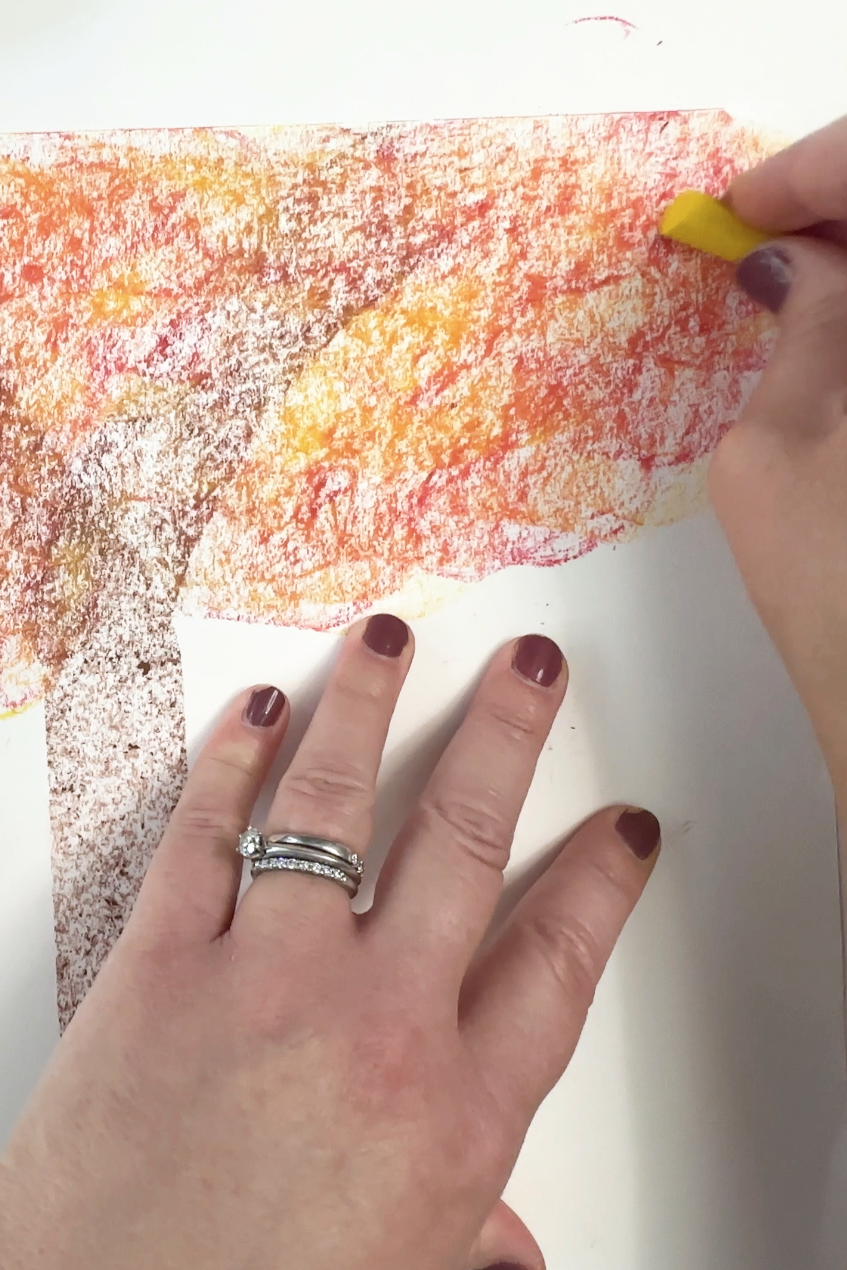 impressionistic fall tree made by layering yellow pastel over red oil pastel