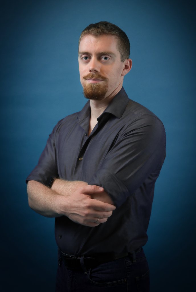 Man smiling with a dark blue background