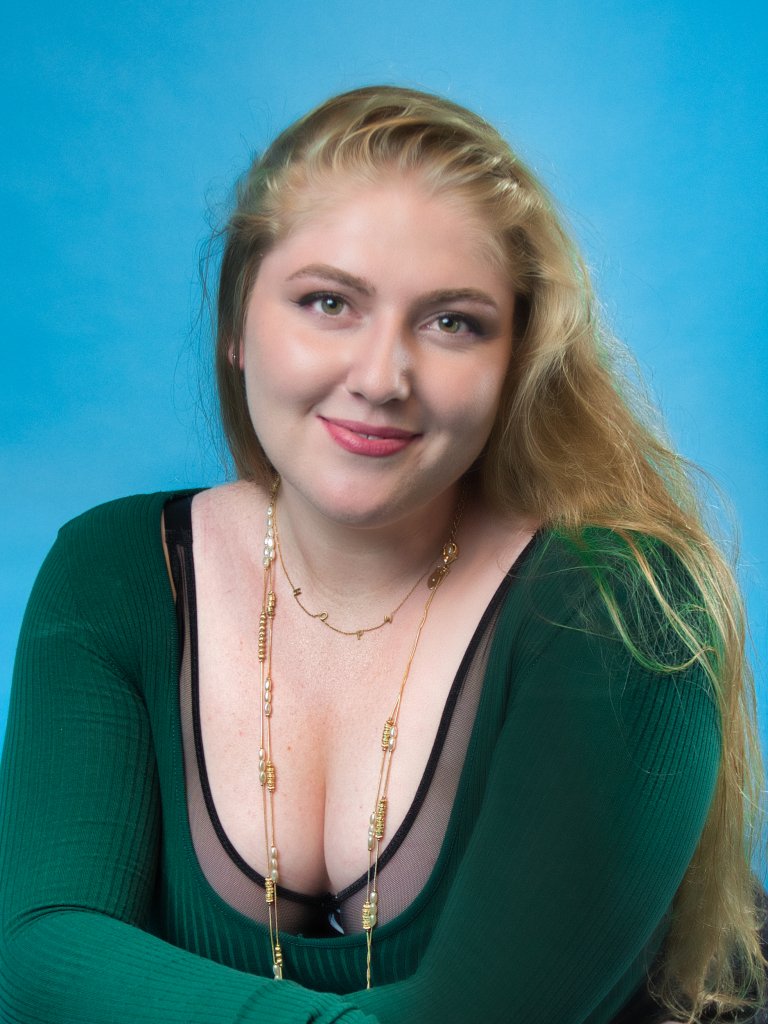 Blonde woman smiling with a blue background