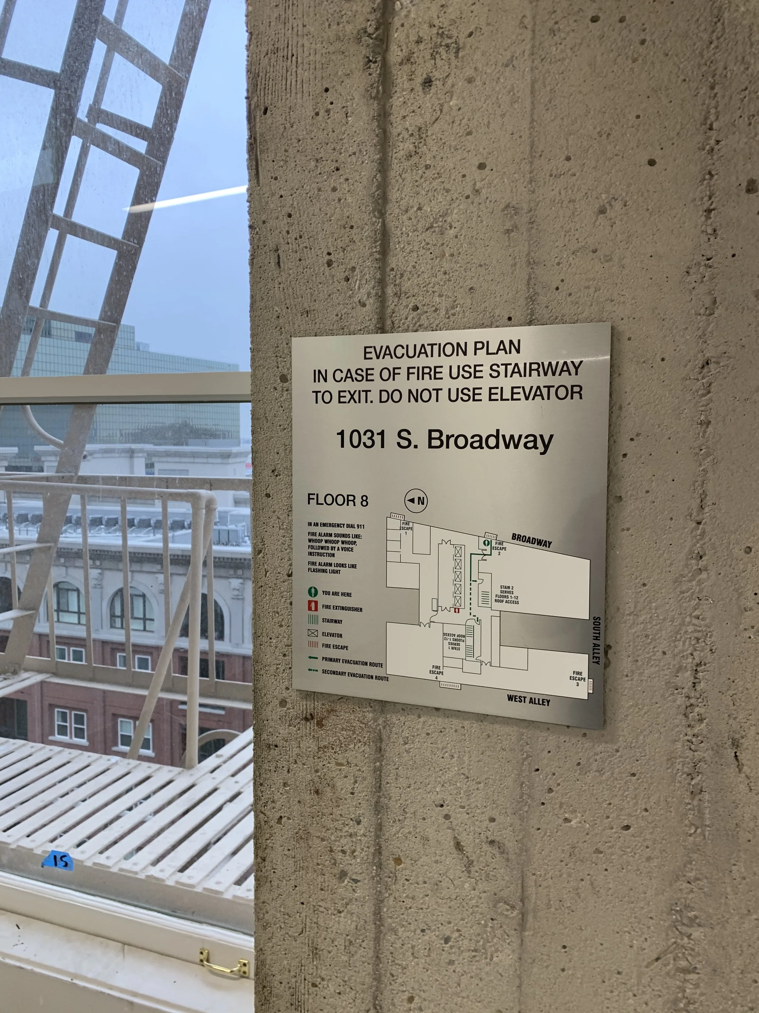 Evacuation sign brushed aluminum face with direct uv printed graphics and black acrylic backer