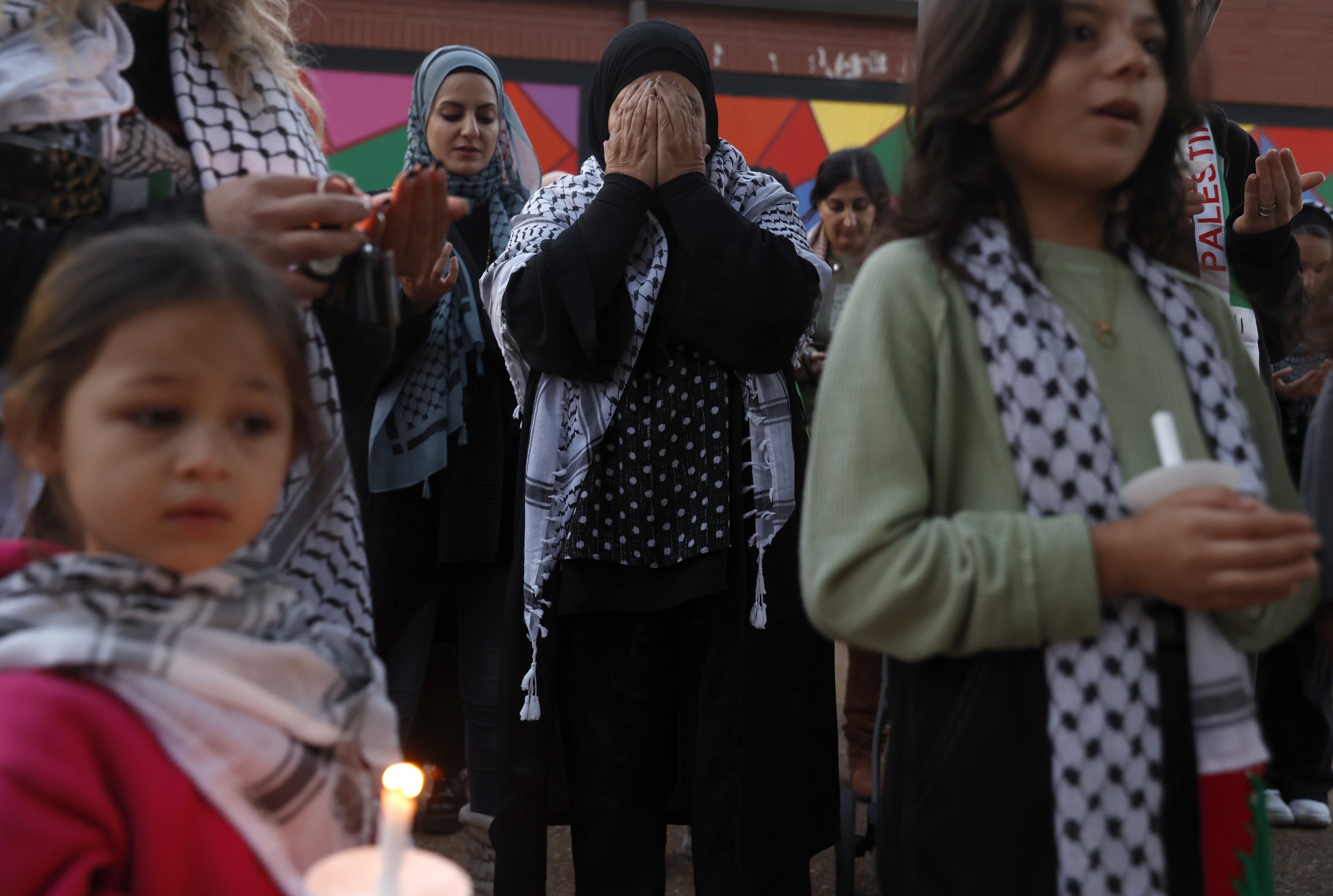  Nima Hamdan, center, prays during a vigil Thursday, Oct. 19, 2023, in the Delmar Loop in St. Louis. Attendees gather to remember the Palestinian lives lost in the ongoing Israel-Hamas war.  