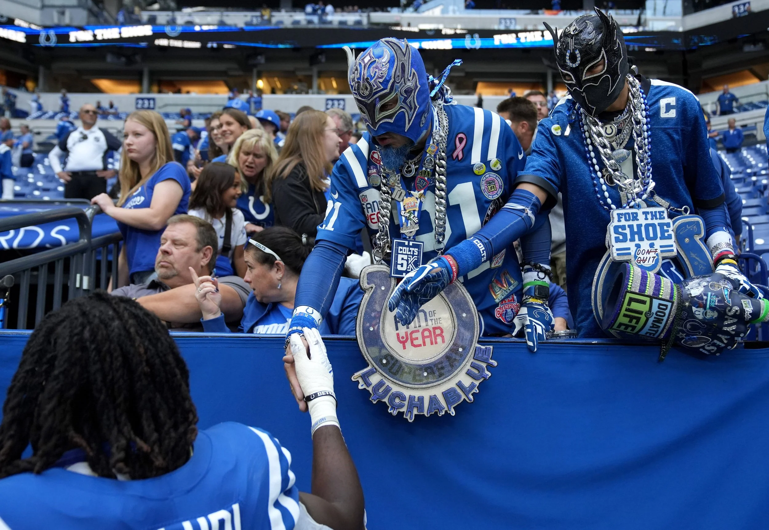  Indianapolis Colts linebacker Segun Olubi (50) gives Eli Otero Jr. (center) and Eli Otero III, 17, a high five as he leaves the field following a game against the Houston Texans on Sunday, Sept. 8, 2024, at Lucas Oil Stadium in Indianapolis. 