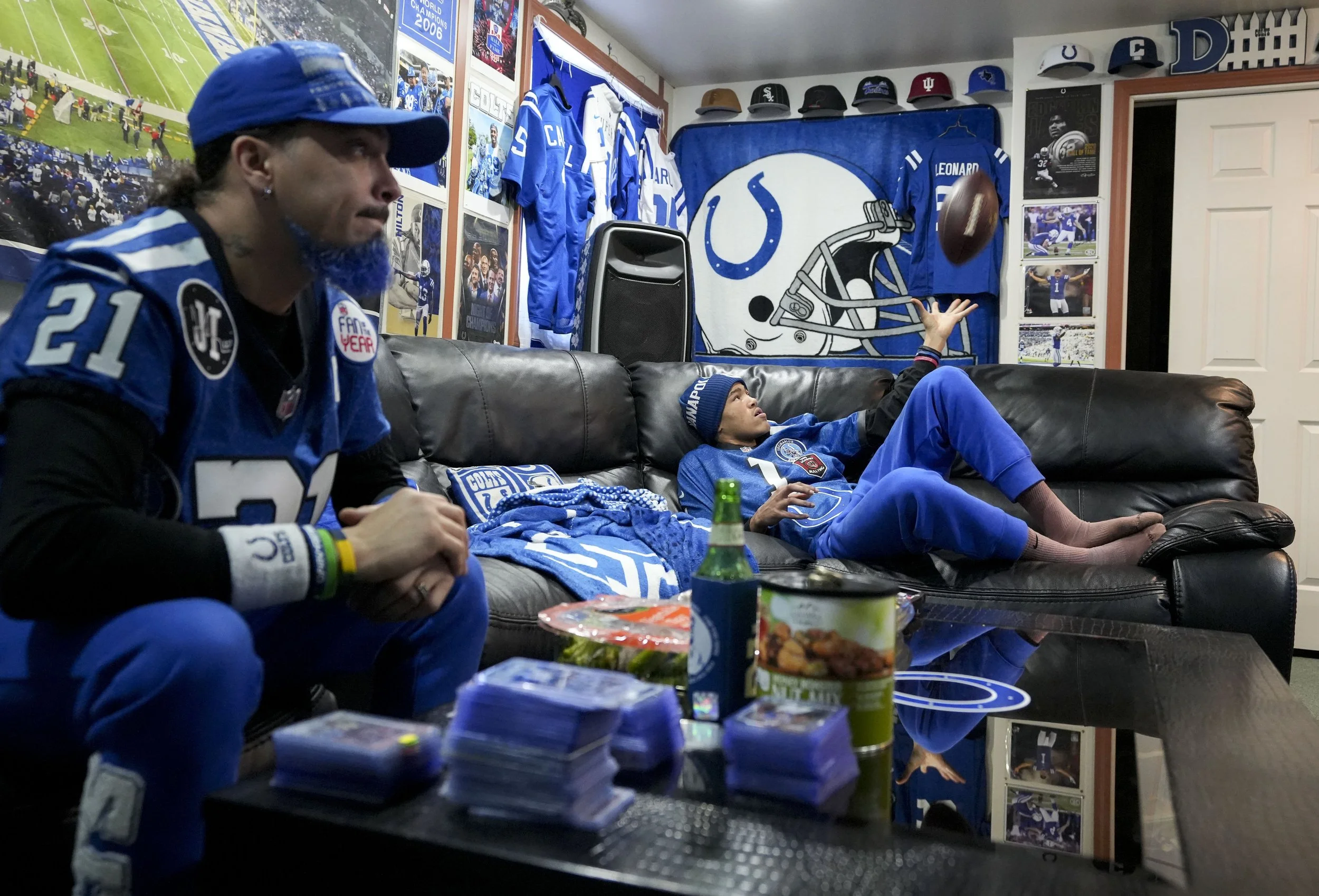  Eli Otero Jr. (left) watches a football game with his son Eli Otero III on Sunday, Dec. 21, 2025, at their home in Valparaiso, Ind. The entire basement of their home is decorated with various Indianapolis Colts memorabilia collected by the family ov