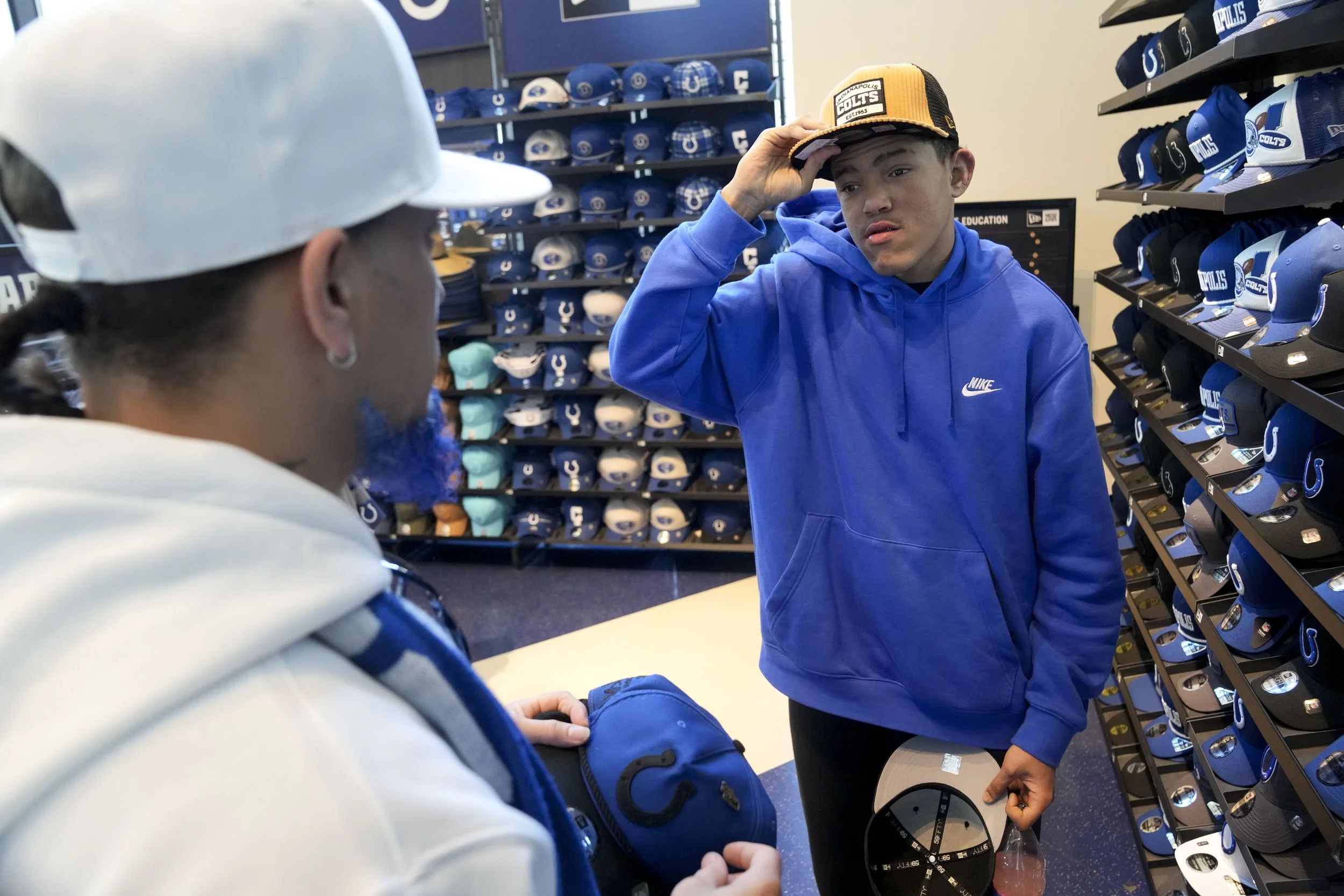 Eli Otero III (right) shows off a hat to his dad Eli Otero Jr. on Tuesday, Dec. 17, 2024, at the Colts Pro Shop in Lucas Oil Stadium in Indianapolis. Following hospital visits, it is a tradition for the duo to visit the store and purchase an item. “