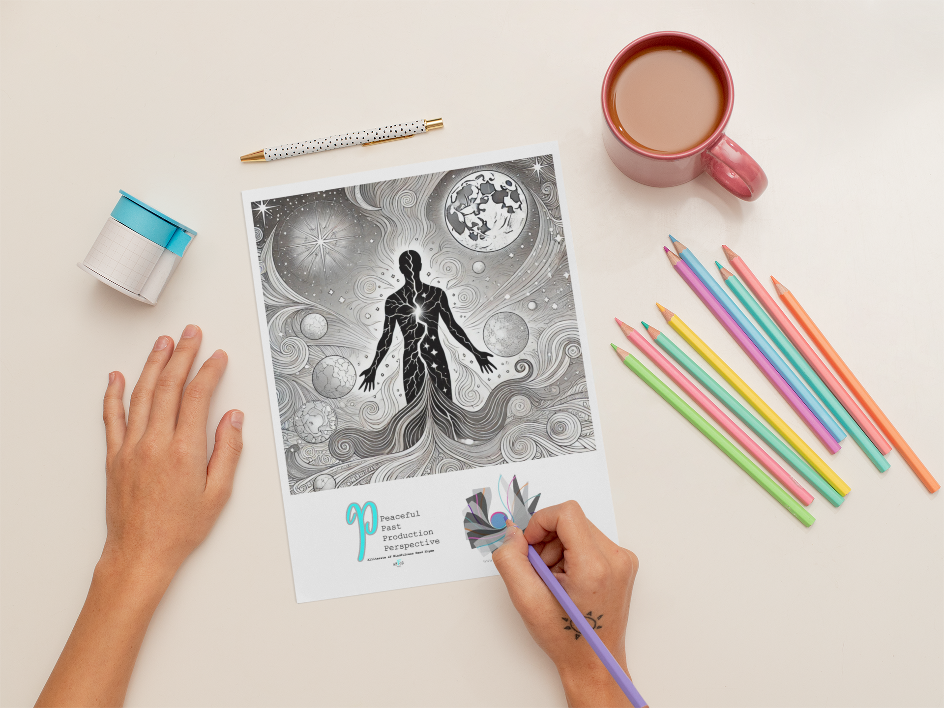 A person coloring a black and white cosmic-themed illustration featuring a human figure with celestial bodies, stars, and swirls on a white desk. The desk also has colorful pencils, a pink cup of coffee, a dotted pen, a small notebook with a blue cover, and a sticker with the words 'Peaceful Past Production Perspective'.