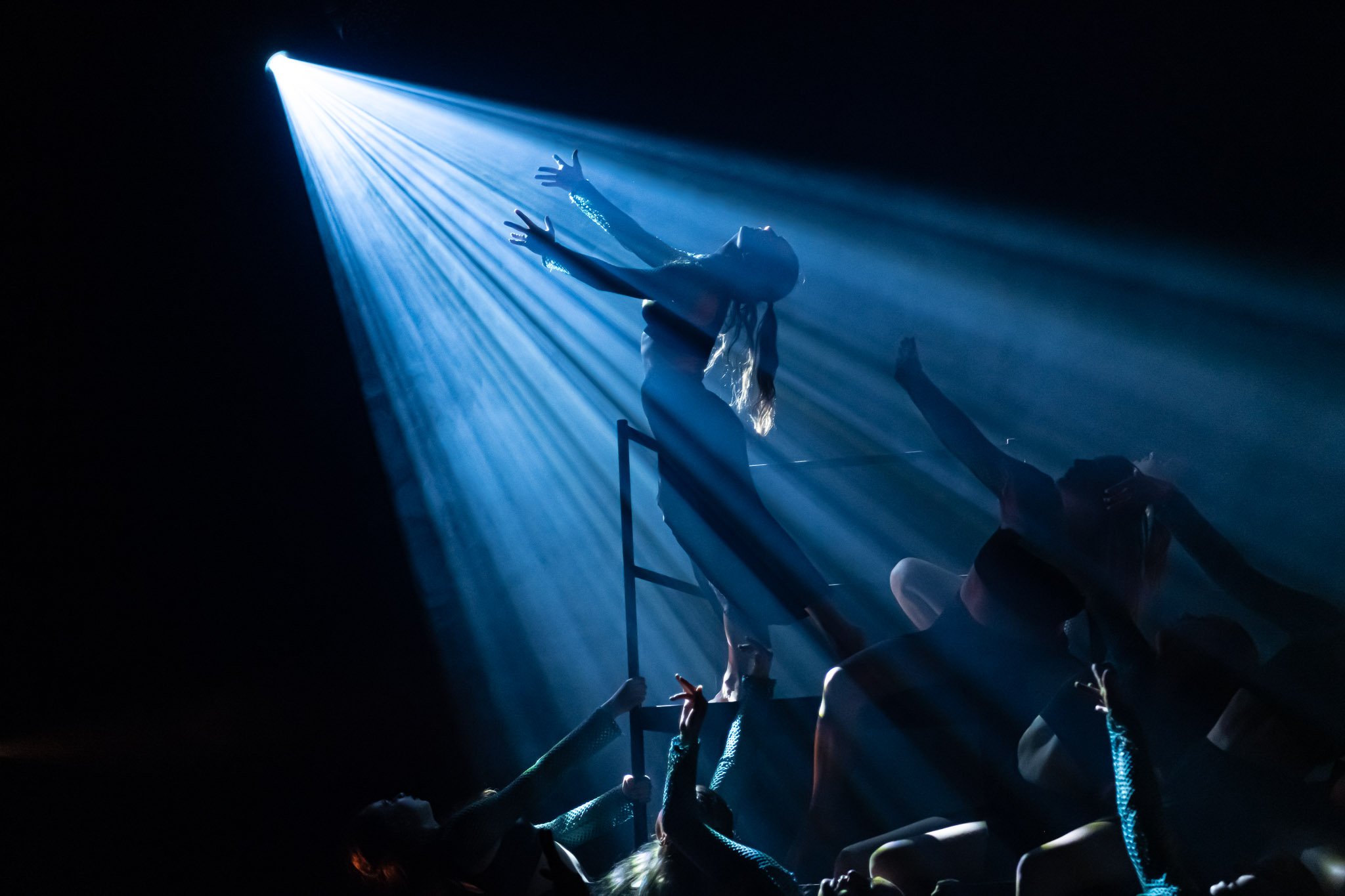 Silhouetted dancer on stage under dramatic lighting