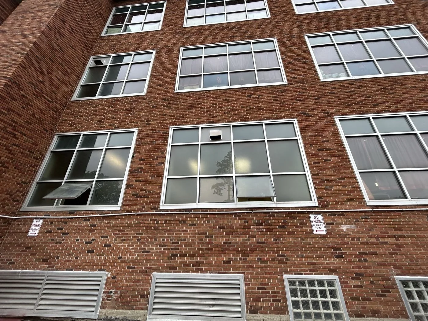 Exterior brick facade and windows of an existing building being evaluated for apartment conversion.