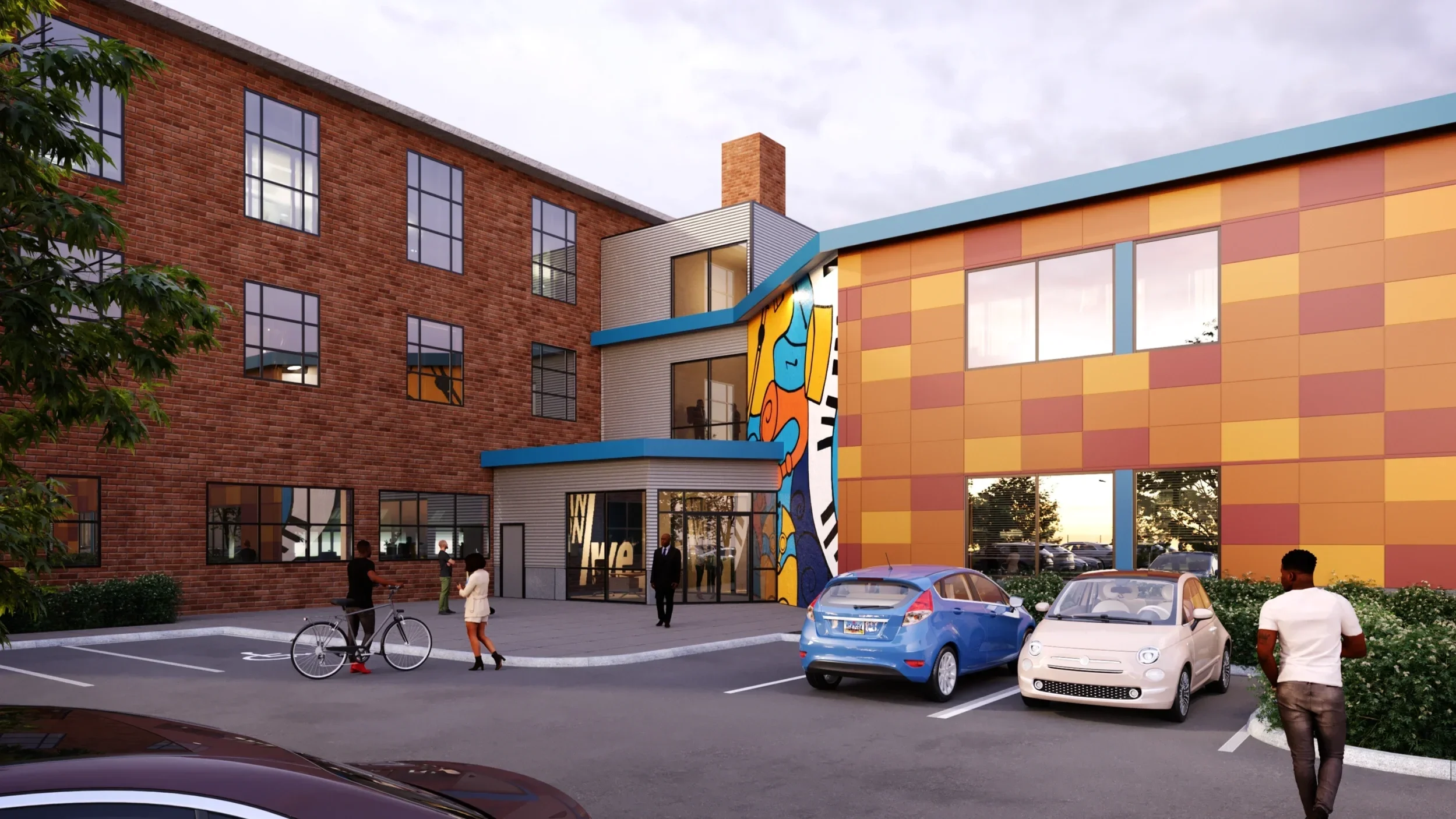 A modern multi-story building with colorful mural art on the wall and a parking lot with several parked cars and people walking or standing outside.