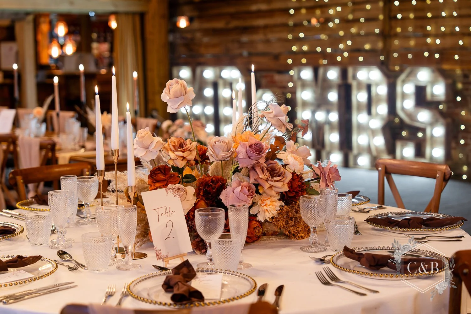 A mocha autumn themed table set-up at Wellington Barn with light up Mr and Mrs letters in the background