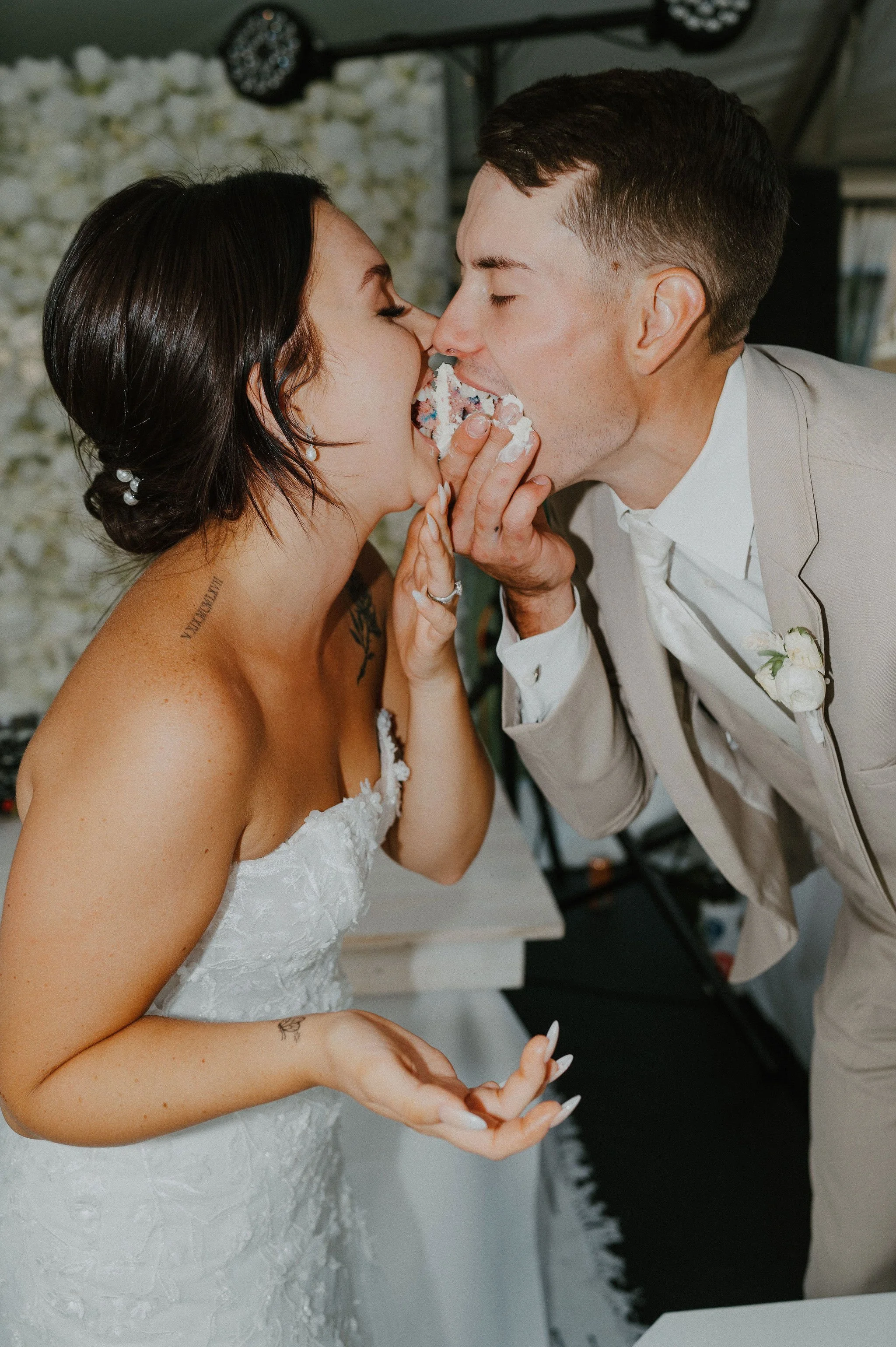 A bride and groom sharing a cake at their wedding celebration.
