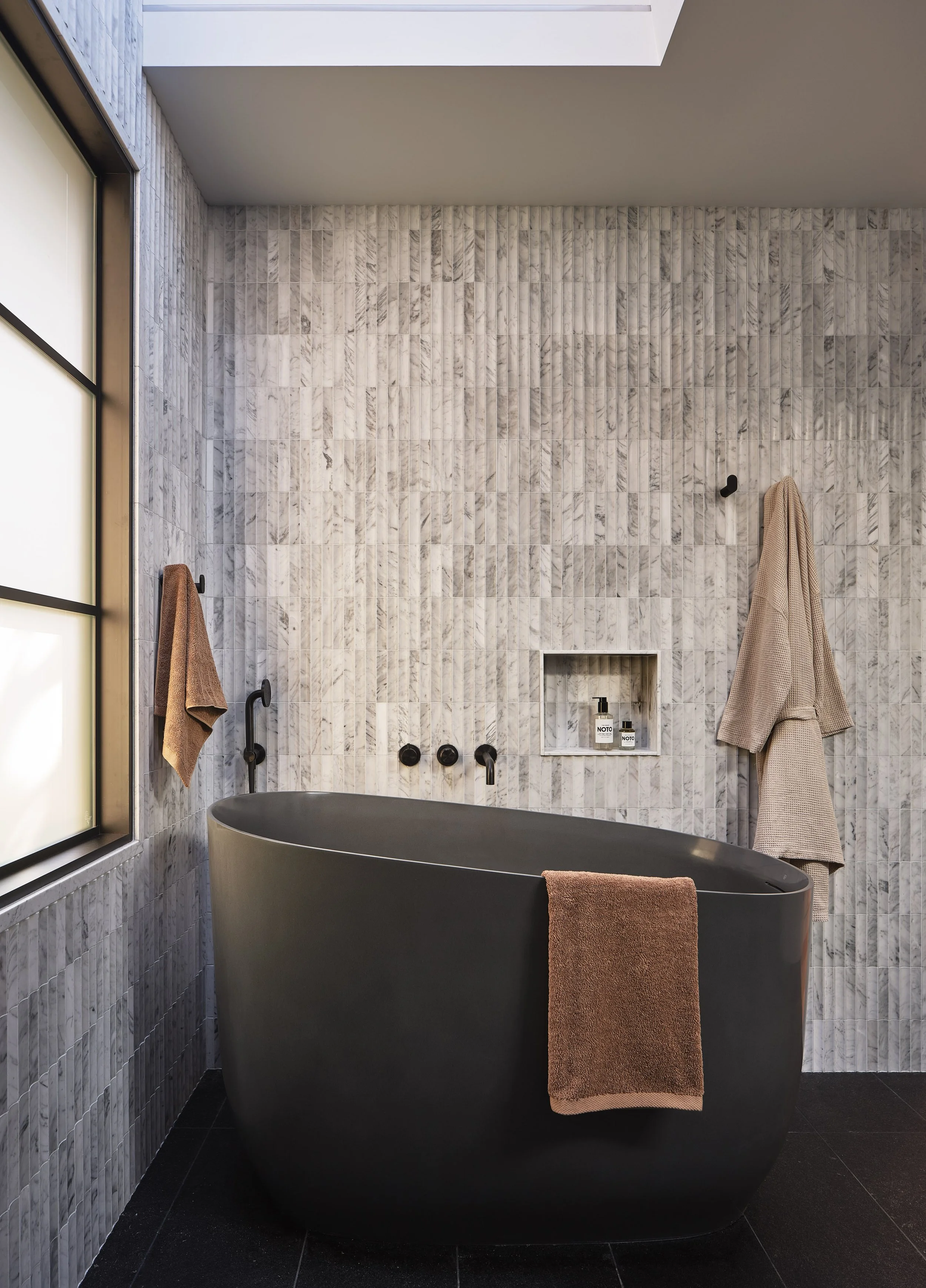 Sculptural bathtub beneath a skylight
