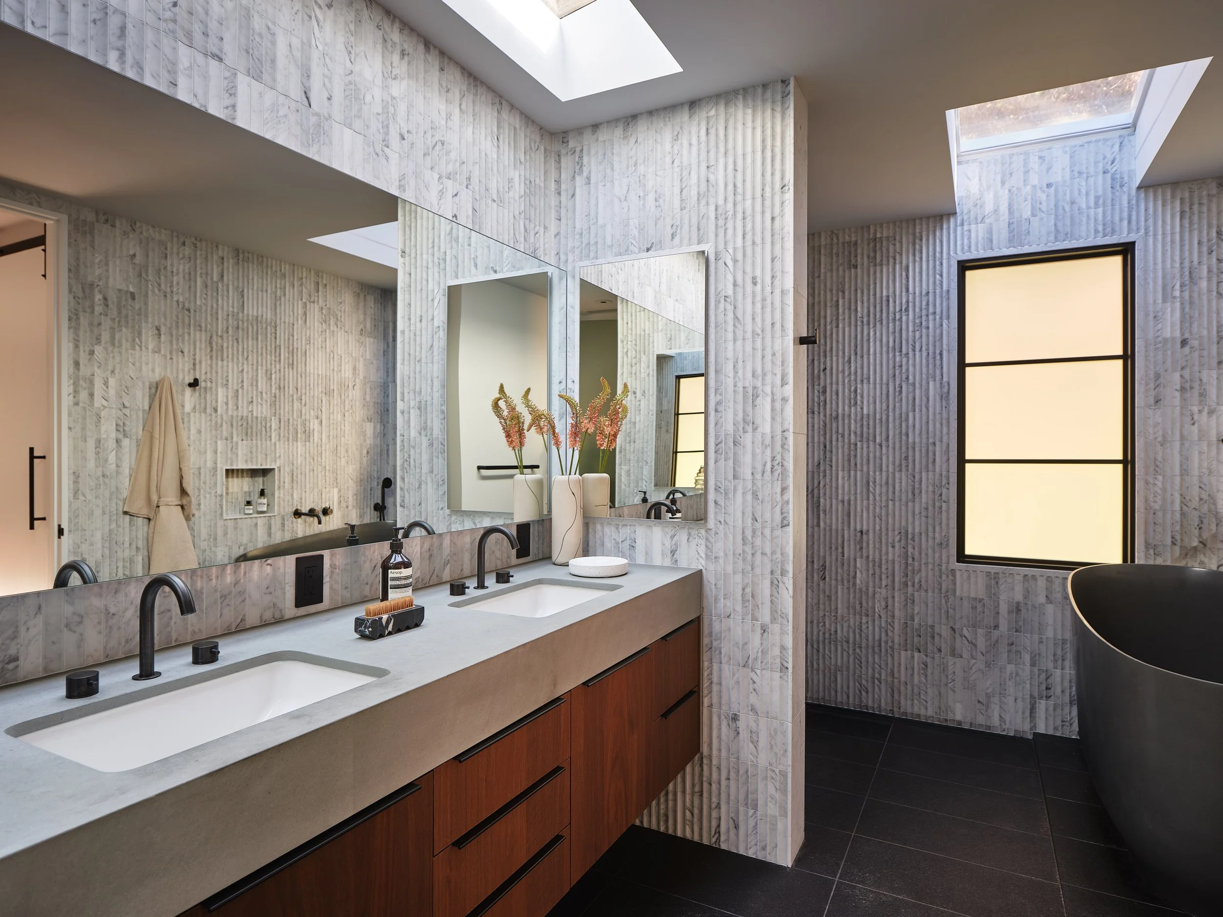 Spa-inspired primary bathroom with warm modern finishes