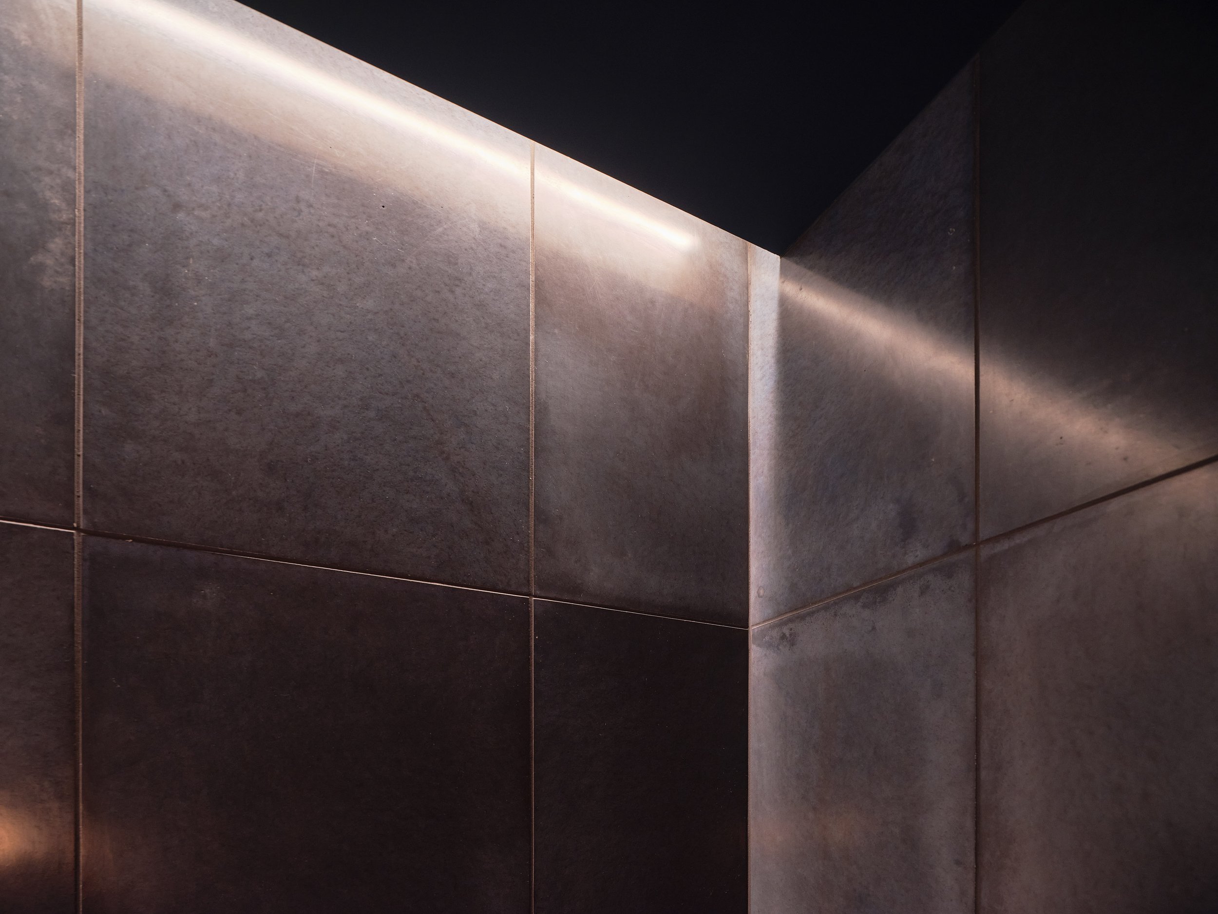 Custom tile detail with wall wash lighting in Lakeshore powder room 