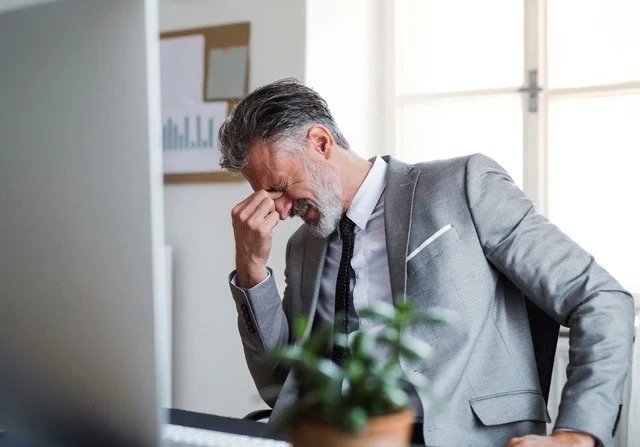 Hermostunut mies nypistää nenäluutaan EU-sääntelyn aiheuttaman stressin takia
