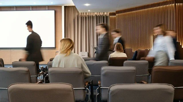 Työntekijät saapumassa auditorioon.