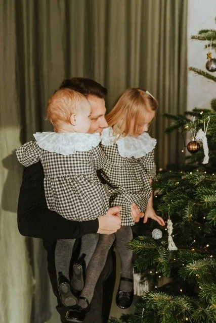 Vanhempi pitämässä lapsiaan kaksin käsin sylissään