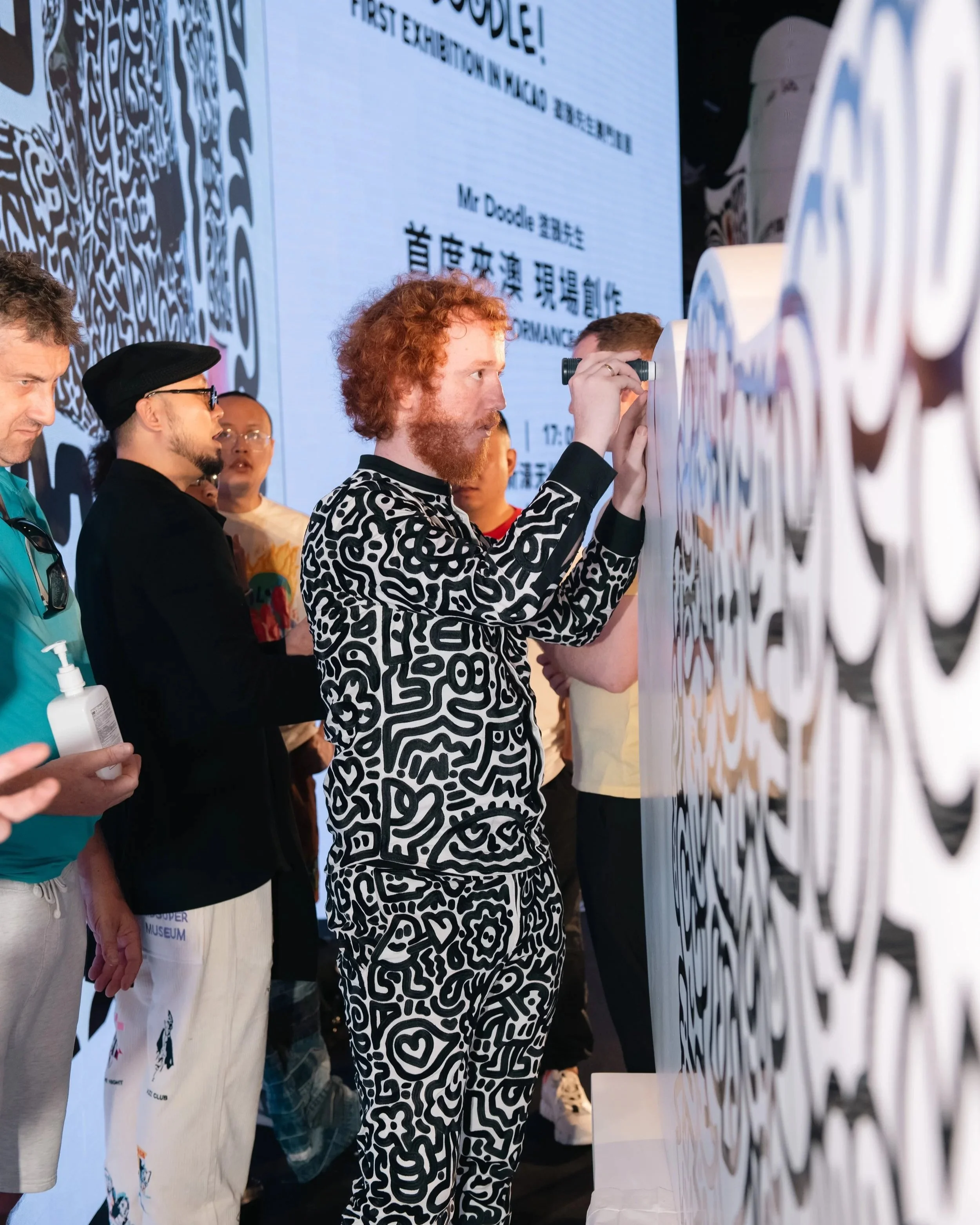 Behind-the-scenes moment capturing Mr Doodle creating artwork live during the exhibition opening.