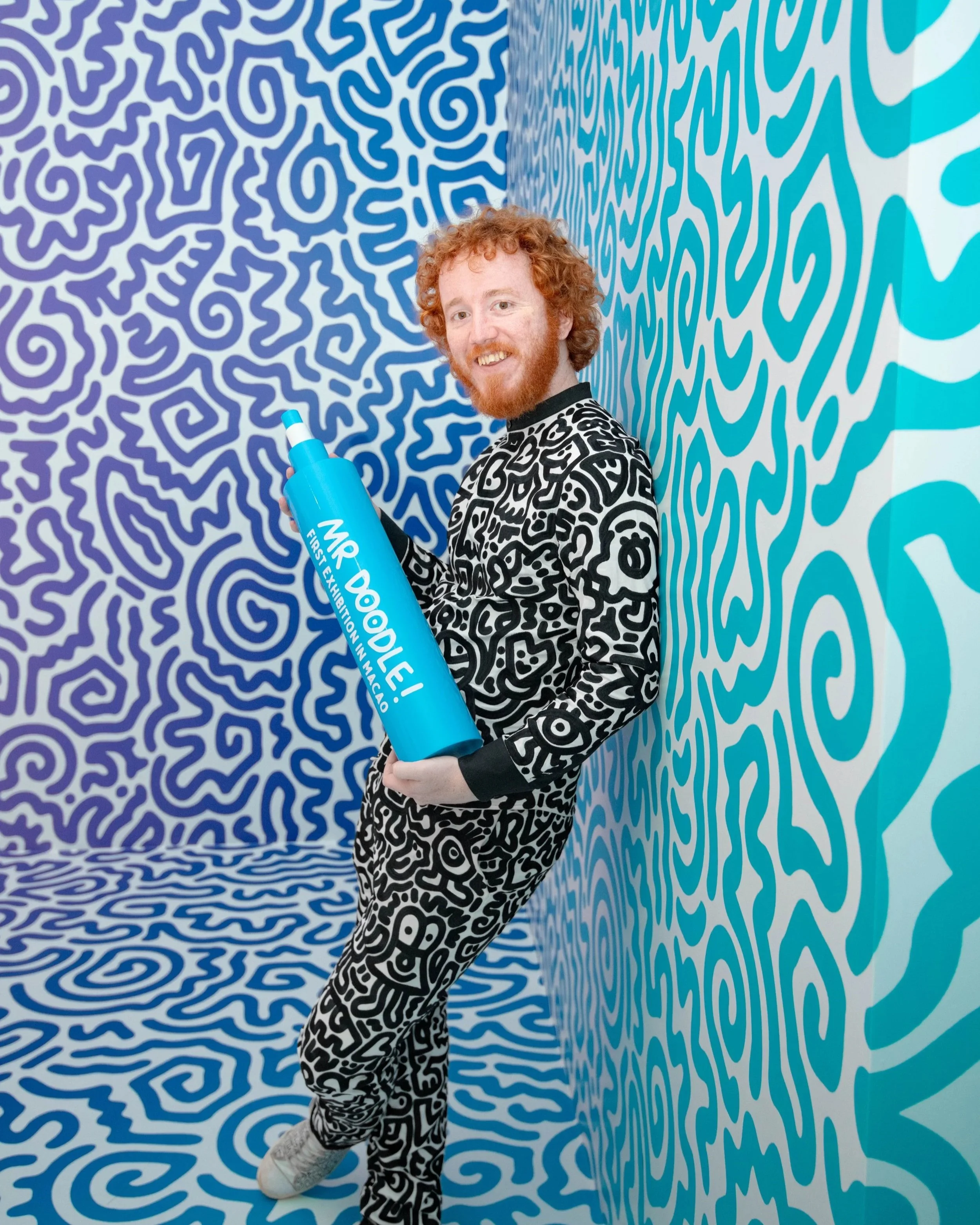 Mr Doodle interacting with a large sculptural piece, reinforcing the playful and performative quality of his work.