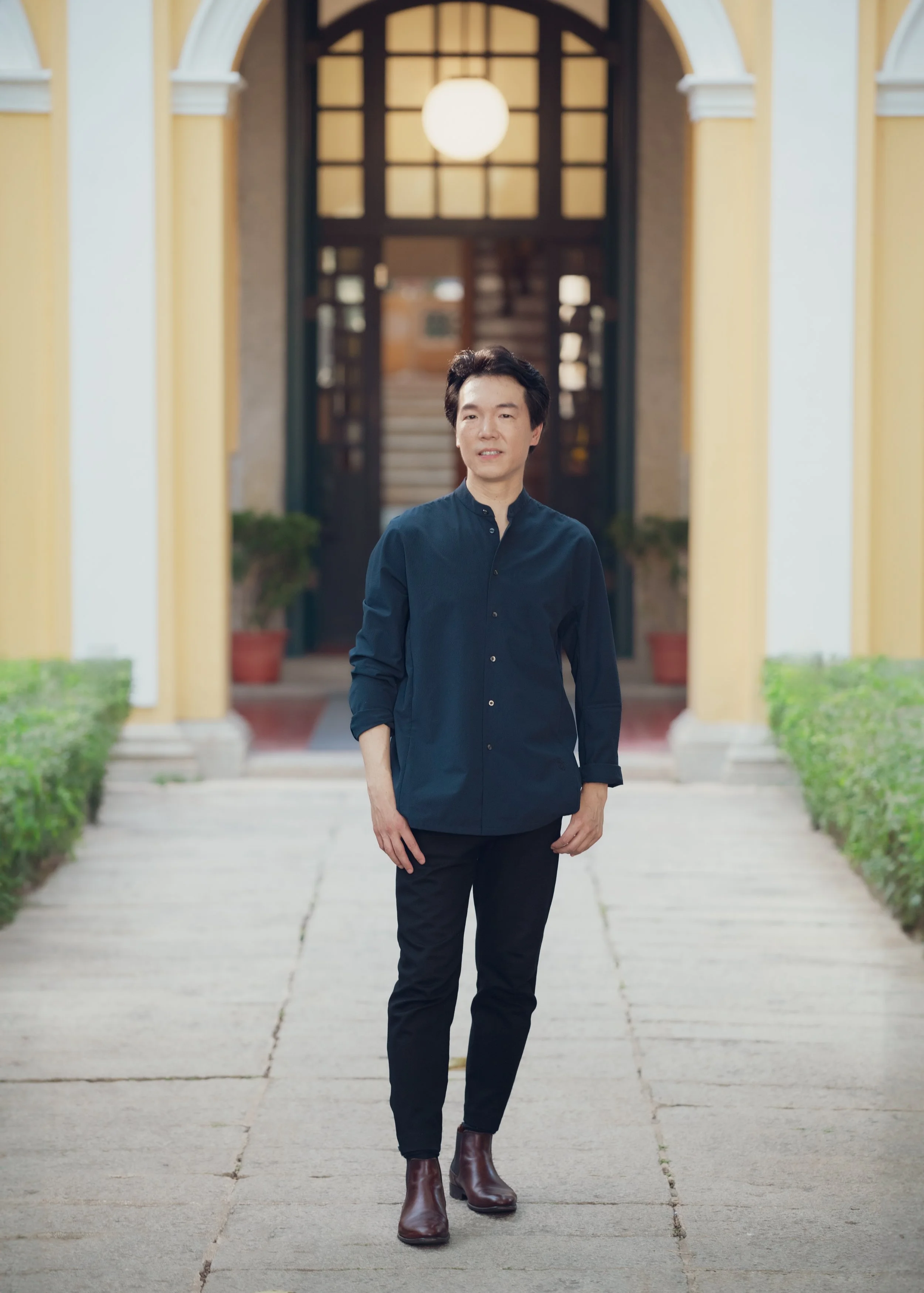 Set against Macau’s historic cityscape, Lio Kuokman represents a new generation of conductors bridging local cultural identity with the international classical music stage.
在澳門歷史城市景觀之中，廖國敏象徵着新一代指揮家，將本地文化身份與國際古典音樂舞台連結起來。
