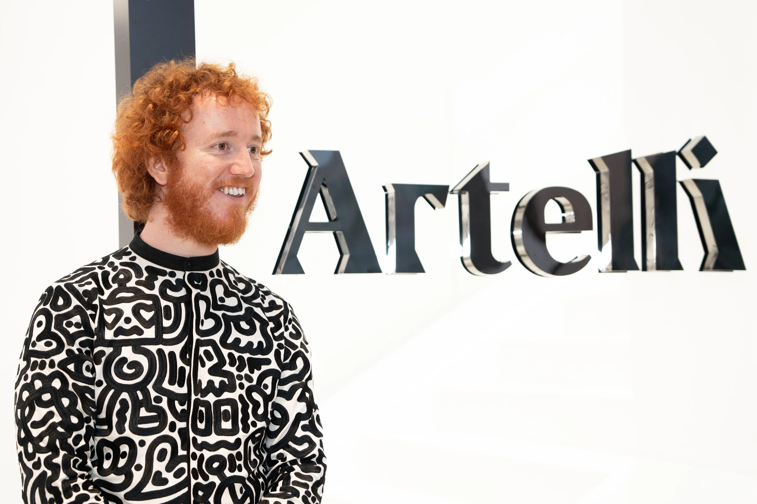 Portrait of Mr Doodle at the Artelli exhibition space, framed by architectural elements and graphic backdrops.