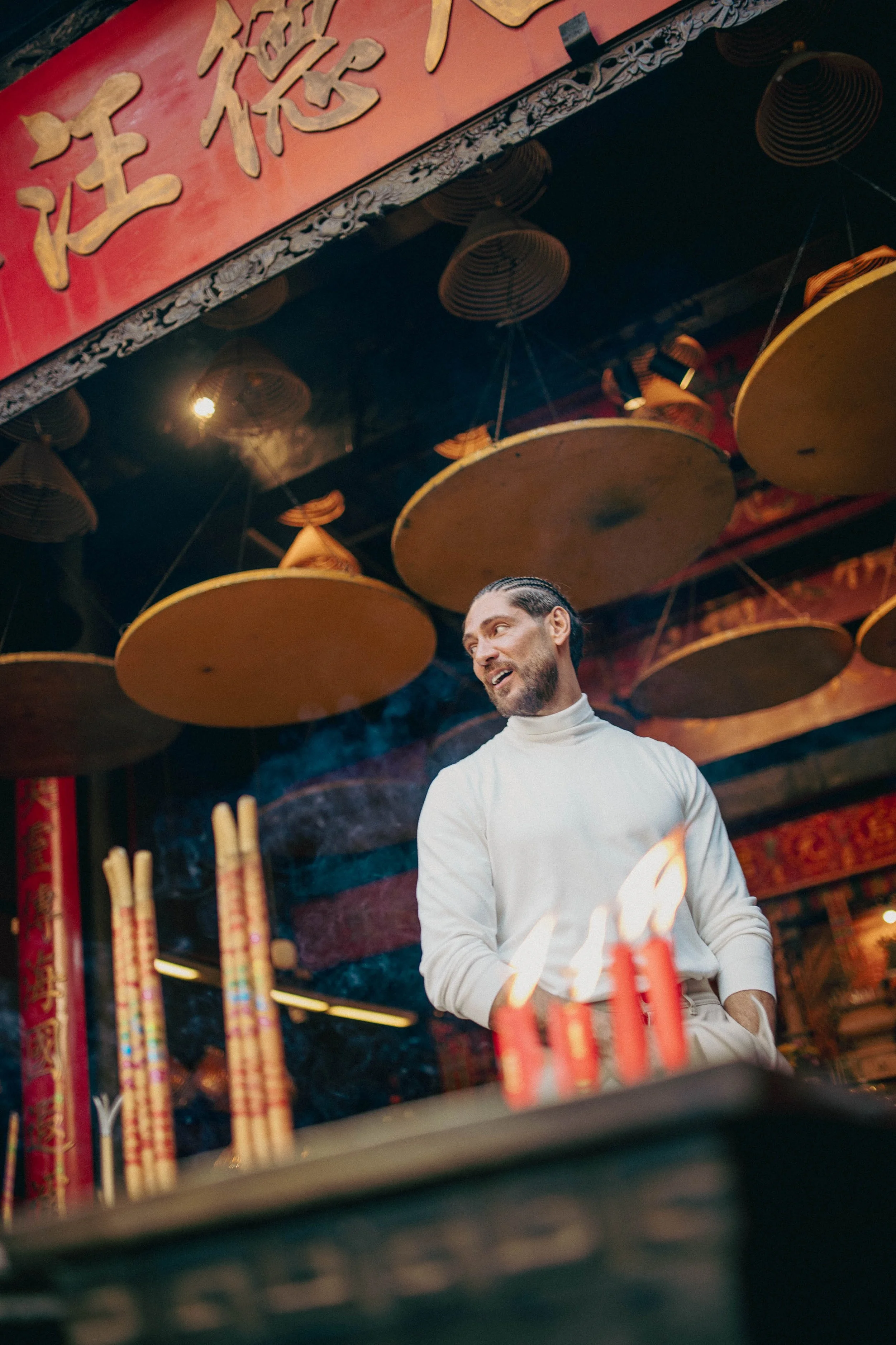 At A-Ma Temple, one of Macau’s oldest and most significant spiritual sites, the portraits shift into a quieter register. Incense smoke, ritual objects, and architectural details surround Angelo Rodrigues, highlighting the city’s spiritual roots and t